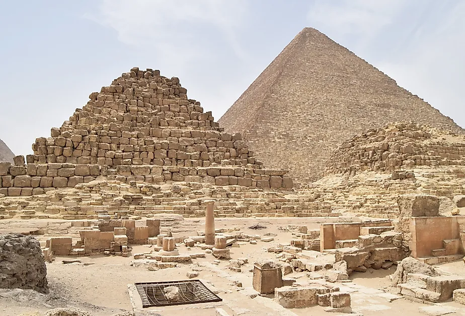 Pyramids of Giza complex in Cairo, Egypt, with Menkaure, Khafre, and Khufu pyramids under clear desert sky.