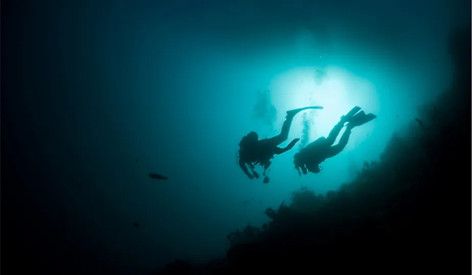 Divers approaching deep ocean depths