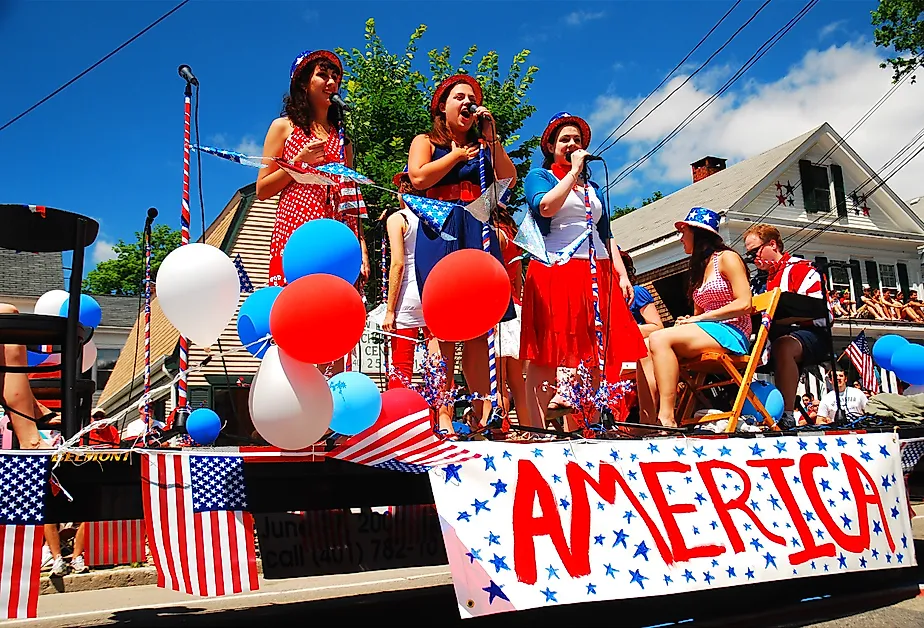 Three teenage girls sing during a Fourth of July parade in Bristol, Rhode Island. Image credit James Kirkikis via Shutterstock