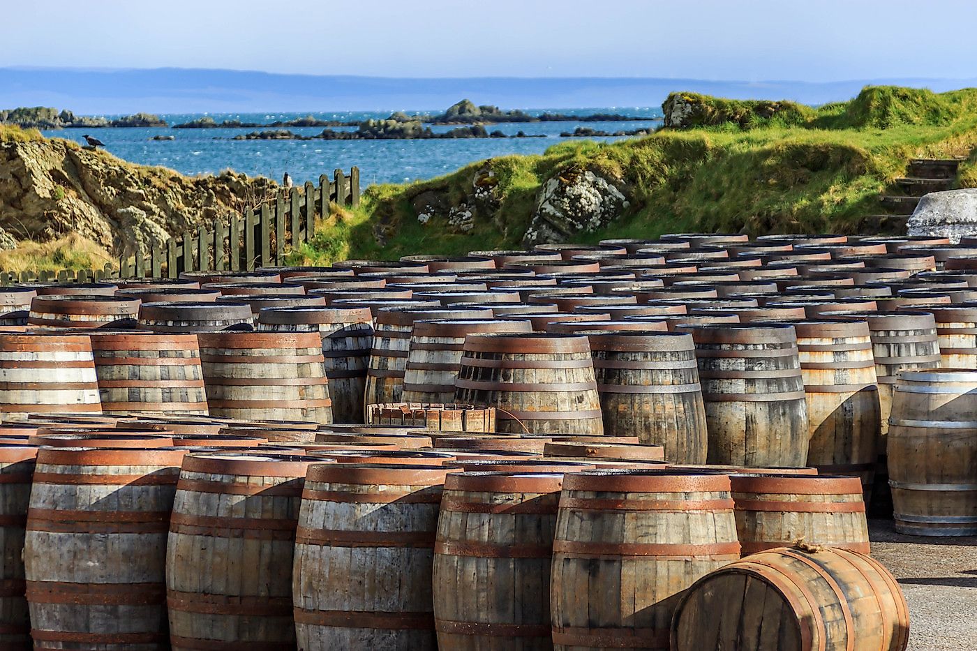 Scotch whisky barrels lined up seaside on the Island of Islay, Scotland UK. Image credit: Rebecca Schochenmaier/Shutterstock.com