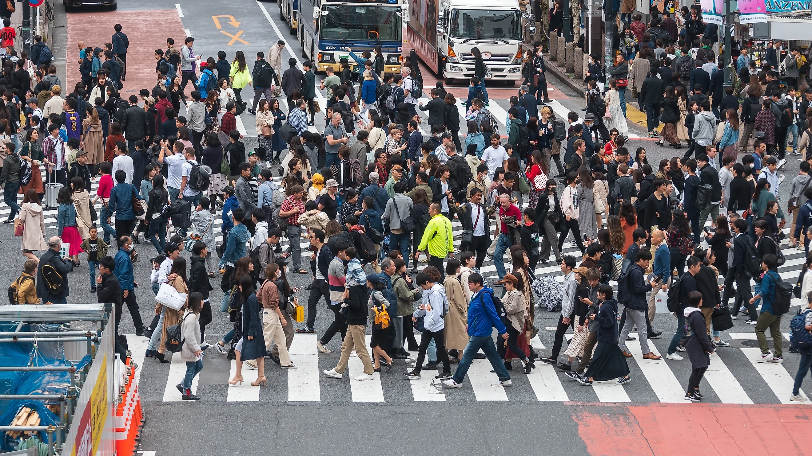 Shibuya crossing with many pedestrians and vehicles crossing the junction in Tokyo, Japan. Editorial credit: Cat Box / Shutterstock.com