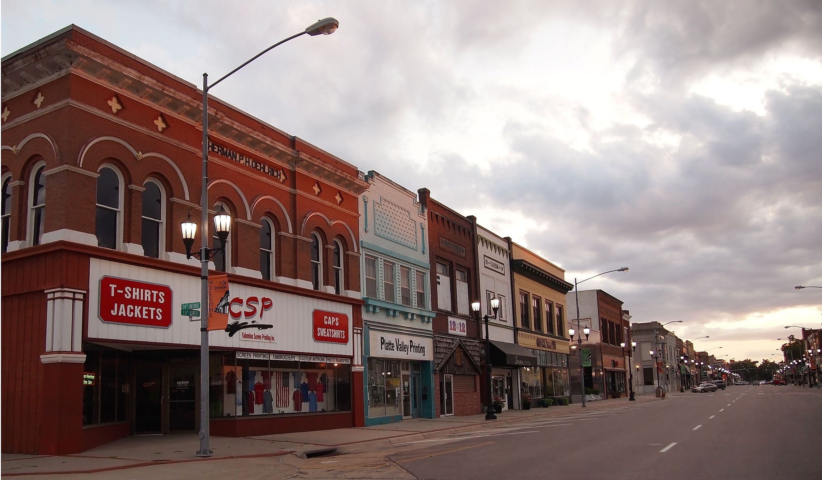 A long street scene with businesses in early 20th century buildings on 13th St. in downtown Columbus, Nebraska. Editorial credit: duckeesue / Shutterstock.com