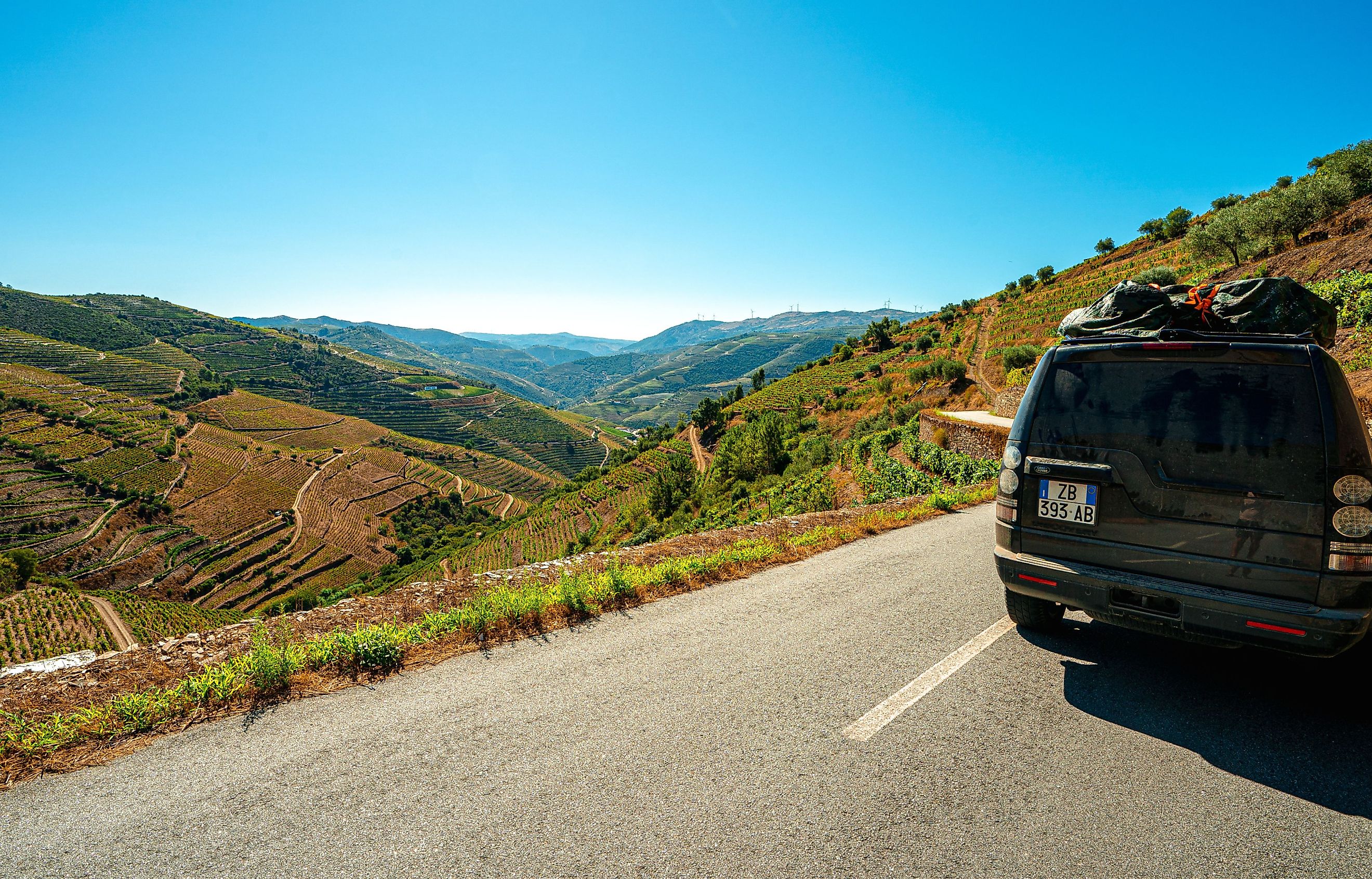 Lifestyle photo of  Land Rover driving along scenic coastline. Image credit FranciscoMarques via Shutterstock