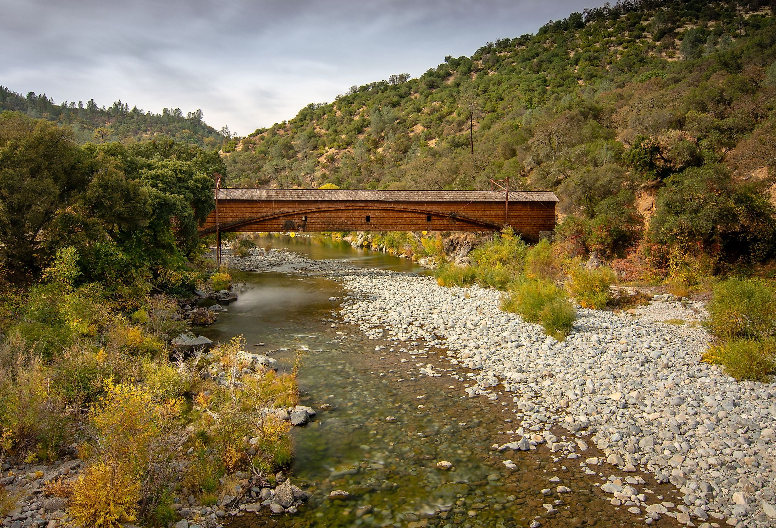 Side view of the Bridgeport Covered Bridge at South Yuba River in California, USA, in the autumn. This bridge has the longest clear span of any surviving covered bridge in the world