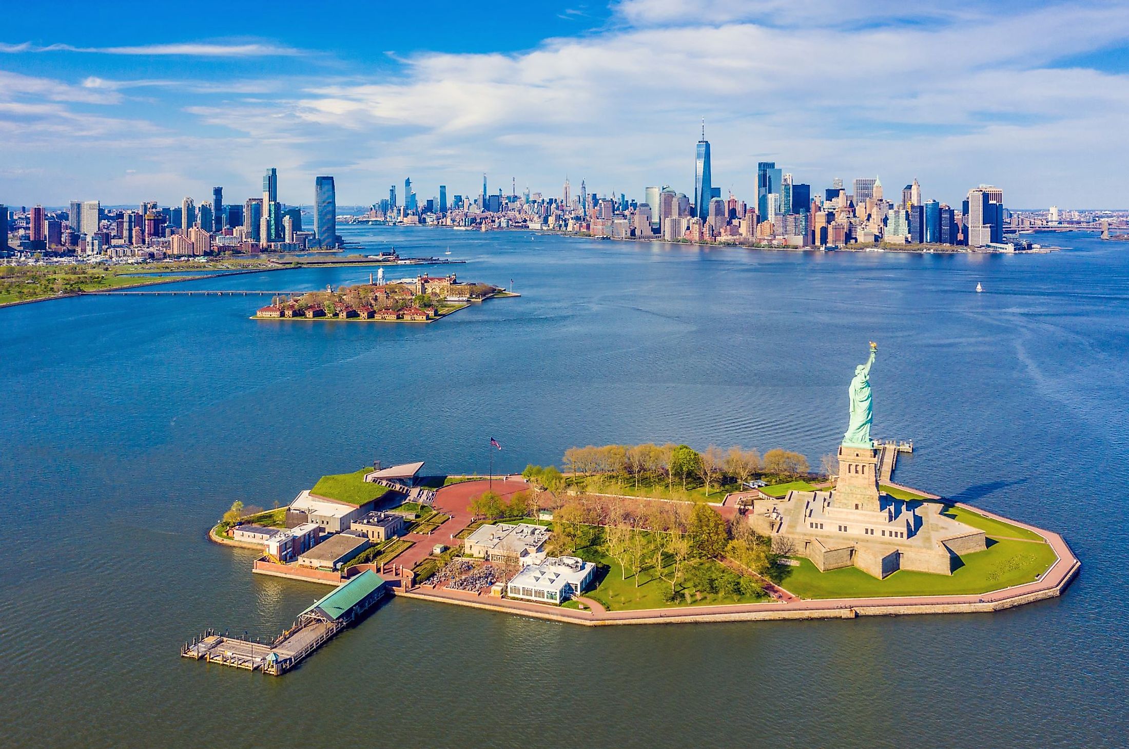 Aerial view of Statue of Liberty, Ellis Island, and Lower Manhattan skyline from New York Harbor near Liberty State Park in New Jersey. 