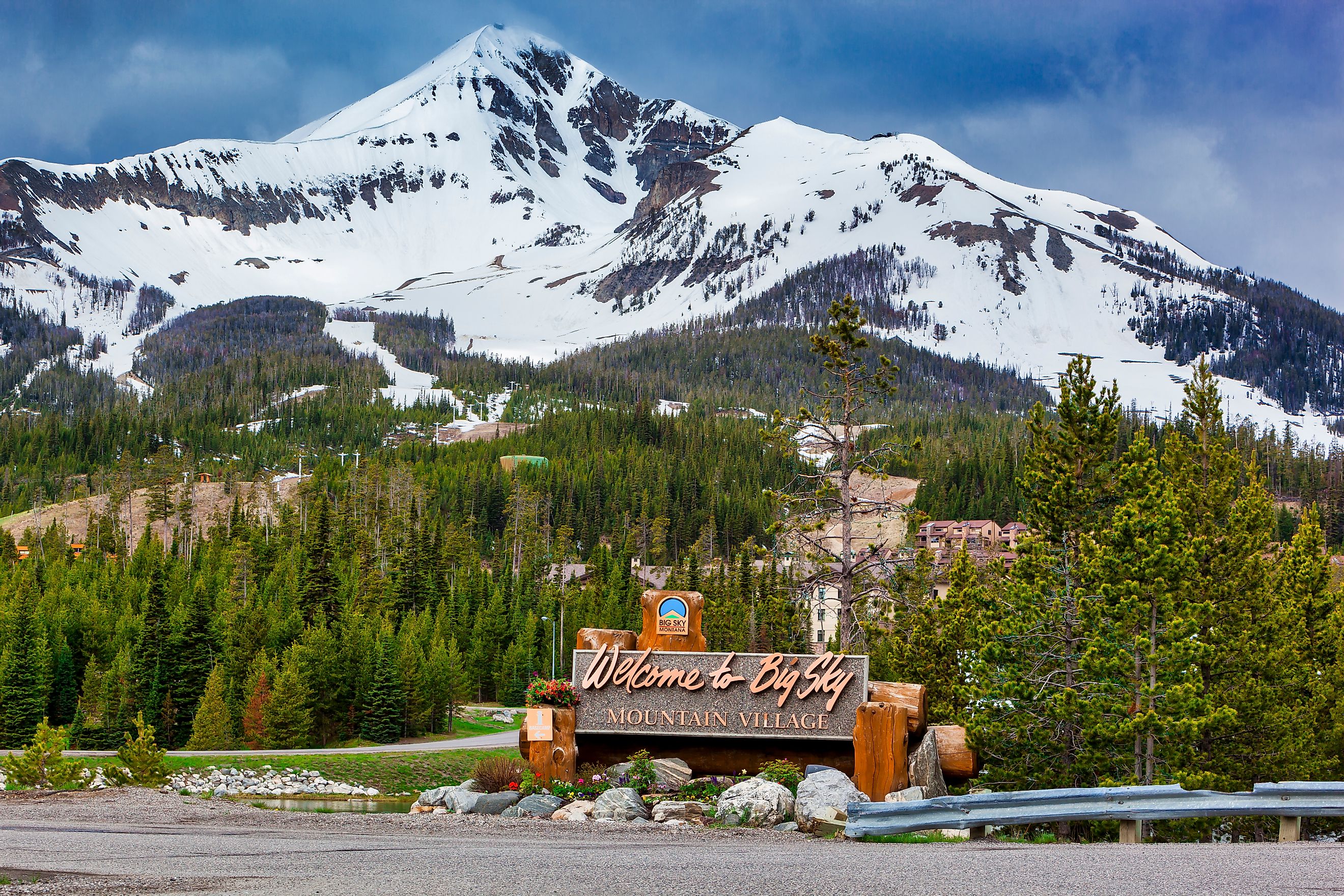 Welcome to Big Sky Mountain Village Signage, dwarfed by the enormity of Lone Mountain full of snow in the Madison Range in the state of Montana. Editorial credit: Zorro Stock Images / Shutterstock.com