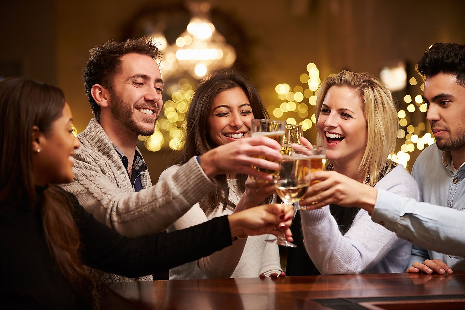Friends enjoying each others' company over drinks at a bar.