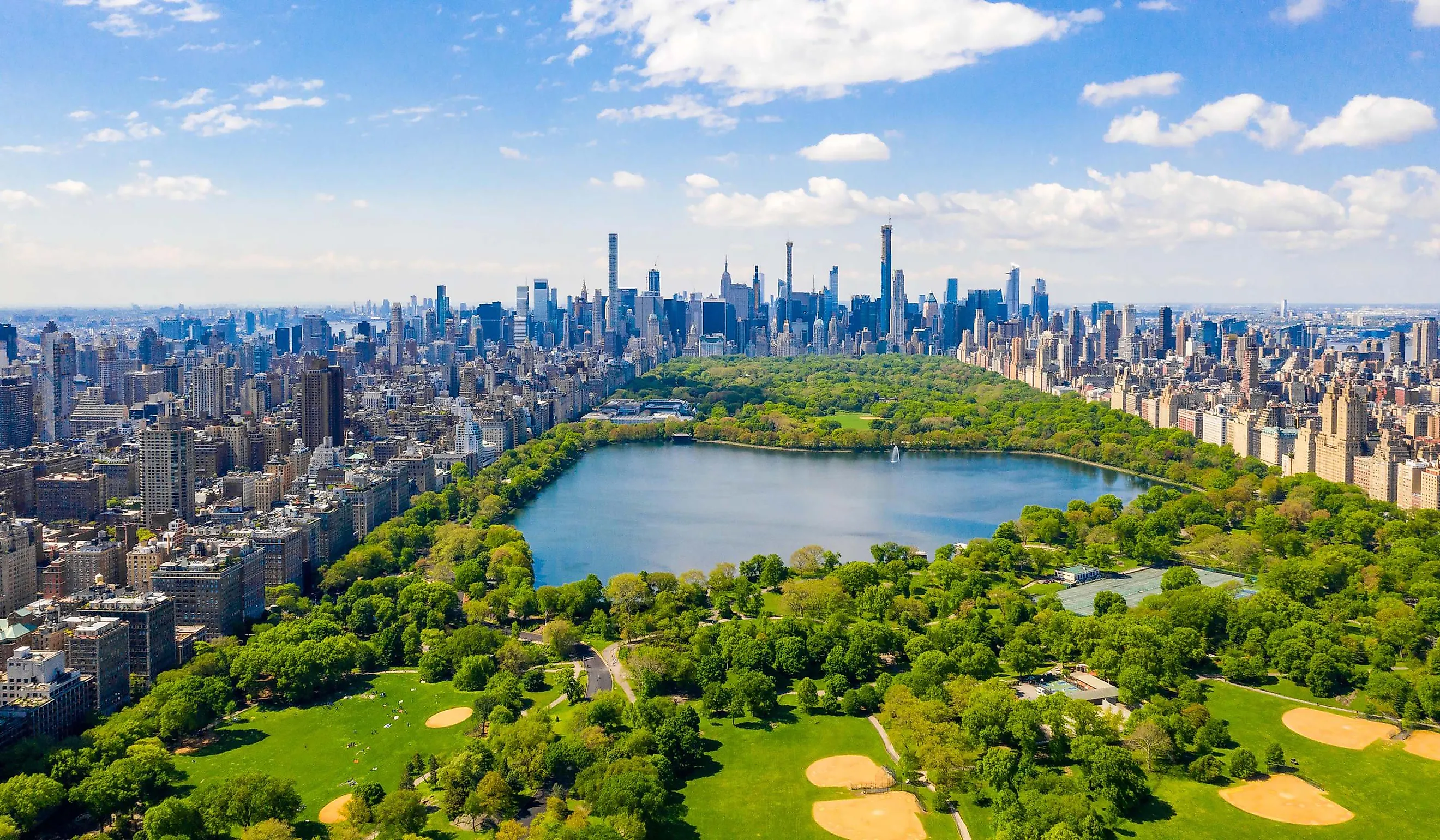 Aerial view of the Central park in New York with golf fields and tall skyscrapers surrounding the park.