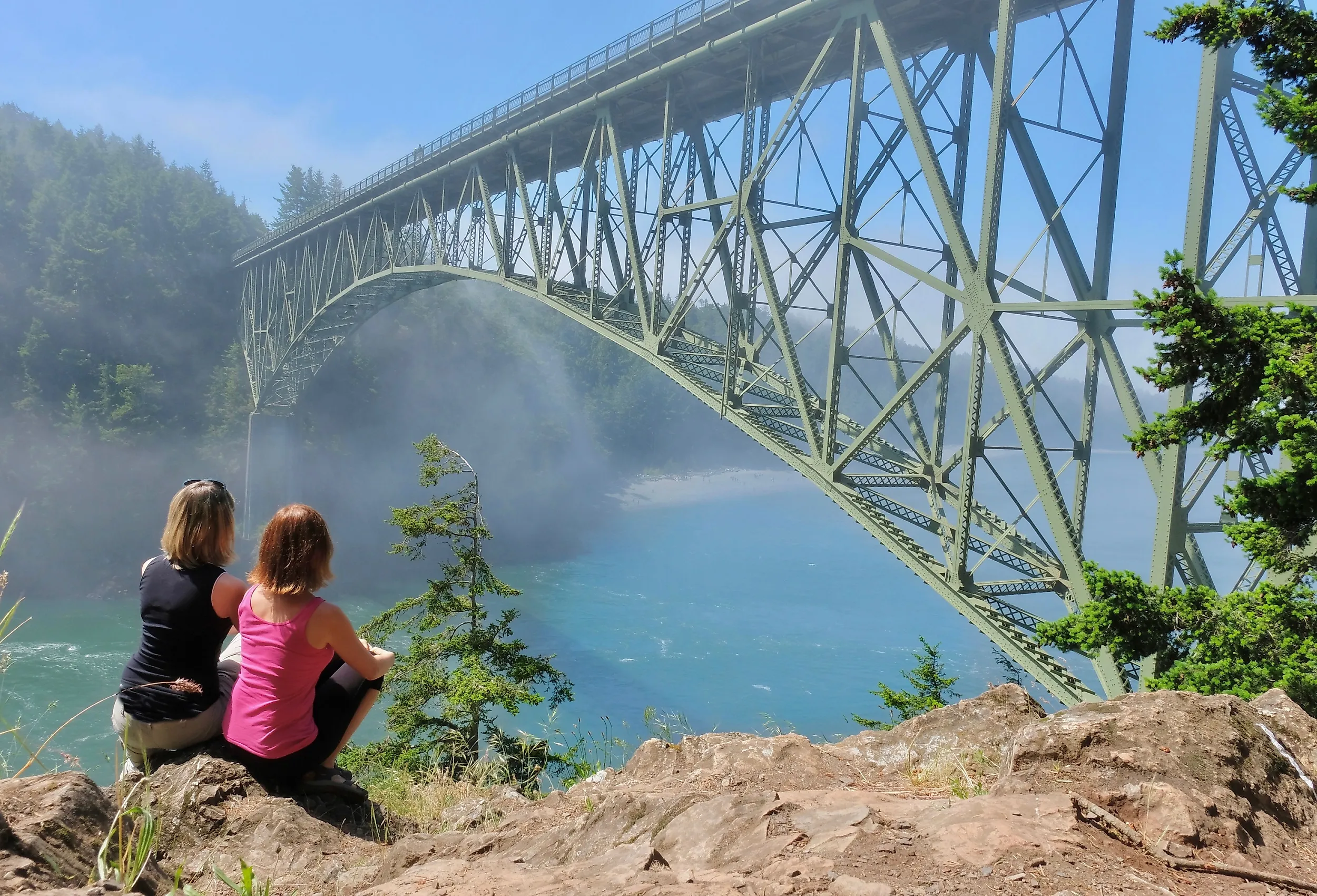 Group of women by ocean in foggy morning in Deception Pass Bridge Park, Anacortes, Washington.