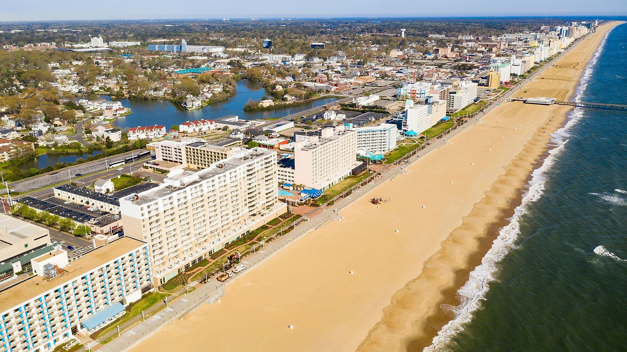 Aerial view of a long row of hotels along an Atlantic Ocean beach in Ocean City, Maryland. 