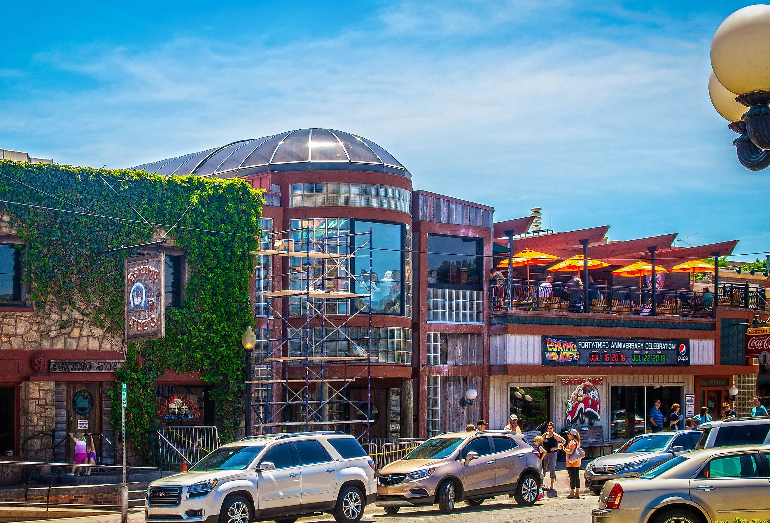 Eskimoo Joes resturant and bar under construction with people standing out front and eating on balcony near Oklahoma State University in Stillwater. Image credit Vineyard Perspective via Shutterstock