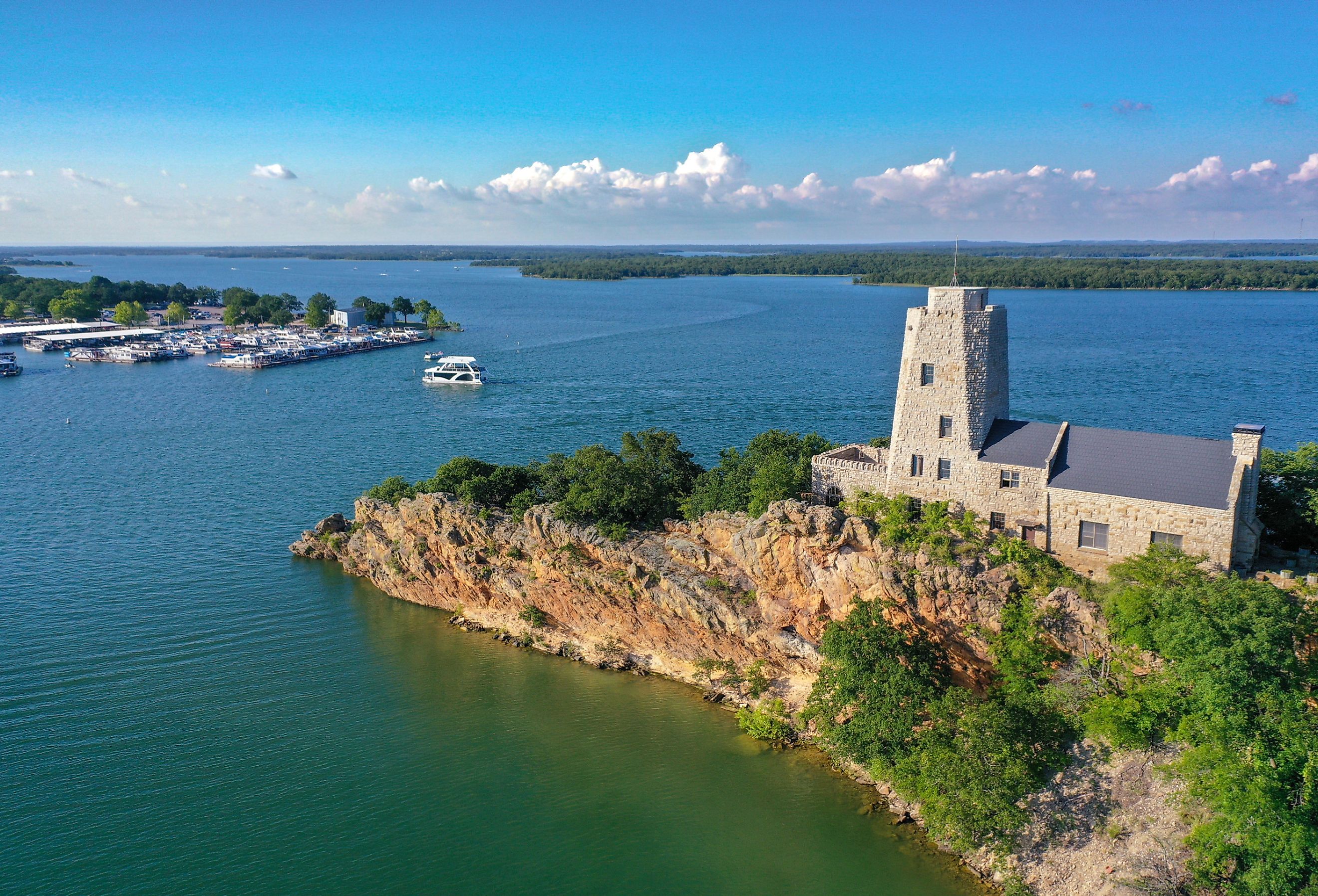 Aerial view of Tucker Tower on Lake Murray in Ardmore Oklahoma on a summer day with a houseboat in the distance.