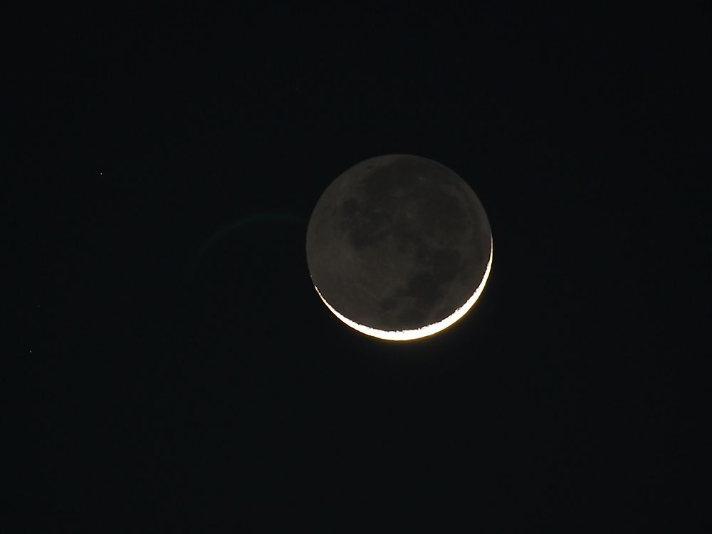 Earthshine blankets the dark side of the moon in a gentle glow.
