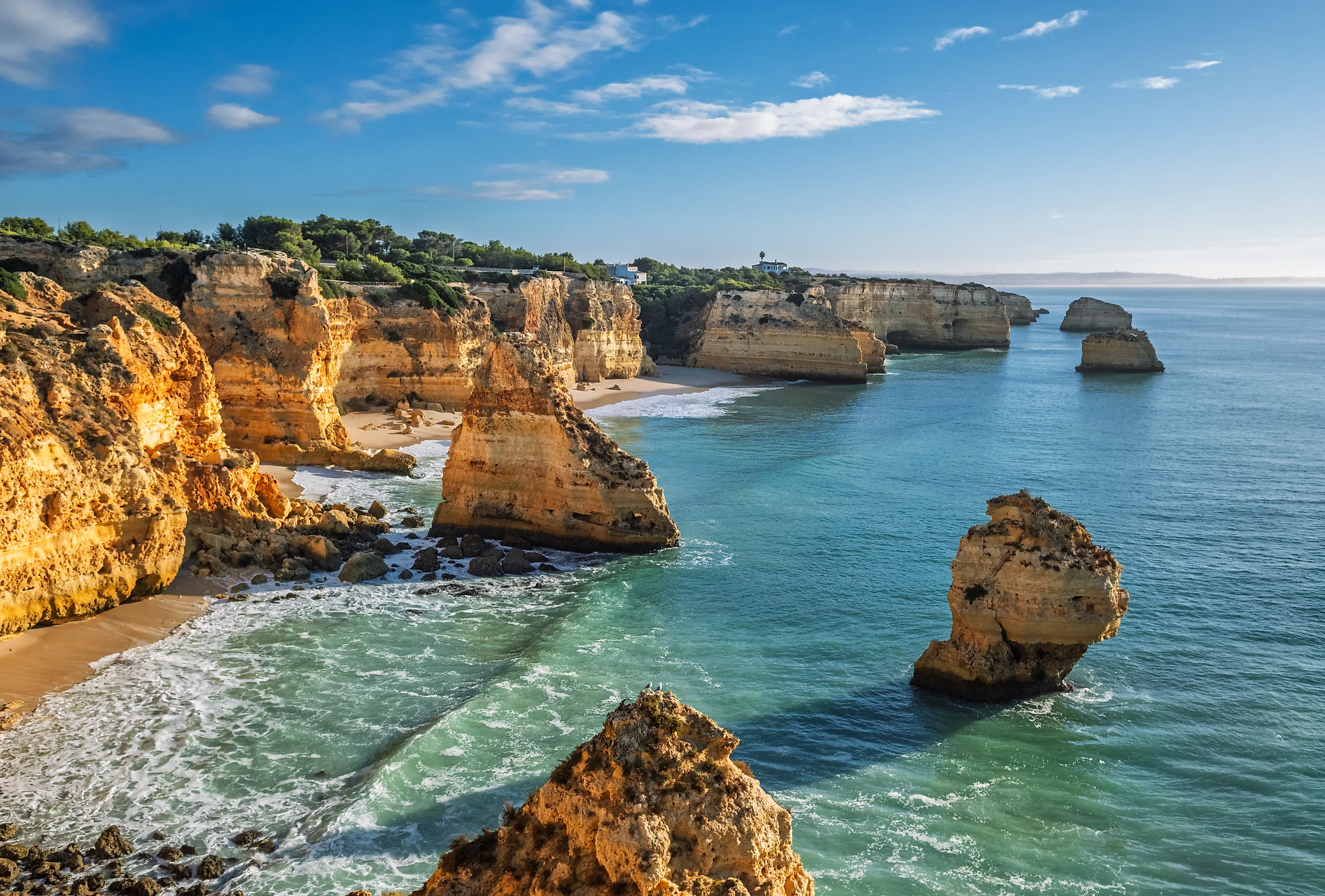 View of Praia da Marinha beach in Algarve, Portugal, with ocean cliffs, sea stacks and scenic coastline. Credit: Dmitry Rukhlenko / Shutterstock