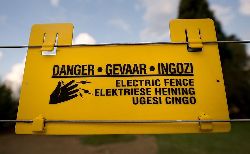 A warning sign in South Africa shown in three languages: English, Africkaans, and Zulu.