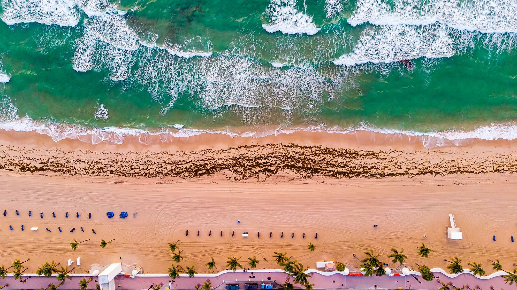 Aerial view of a coastline, Atlantic Ocean waves, and public beach at Delray Beach, Florida. 