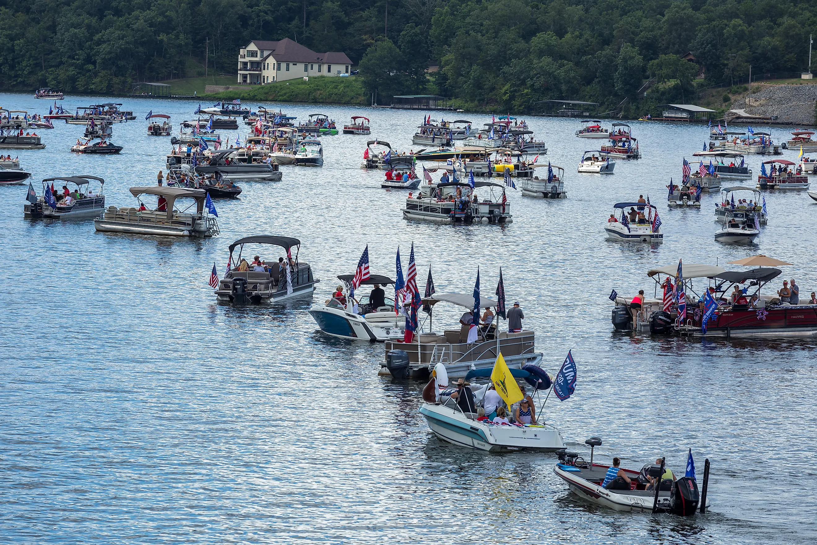 American flags fly in July on Lake Hamilton, Hot Springs, AK. Via Shutterstock / mwesselsphotography.