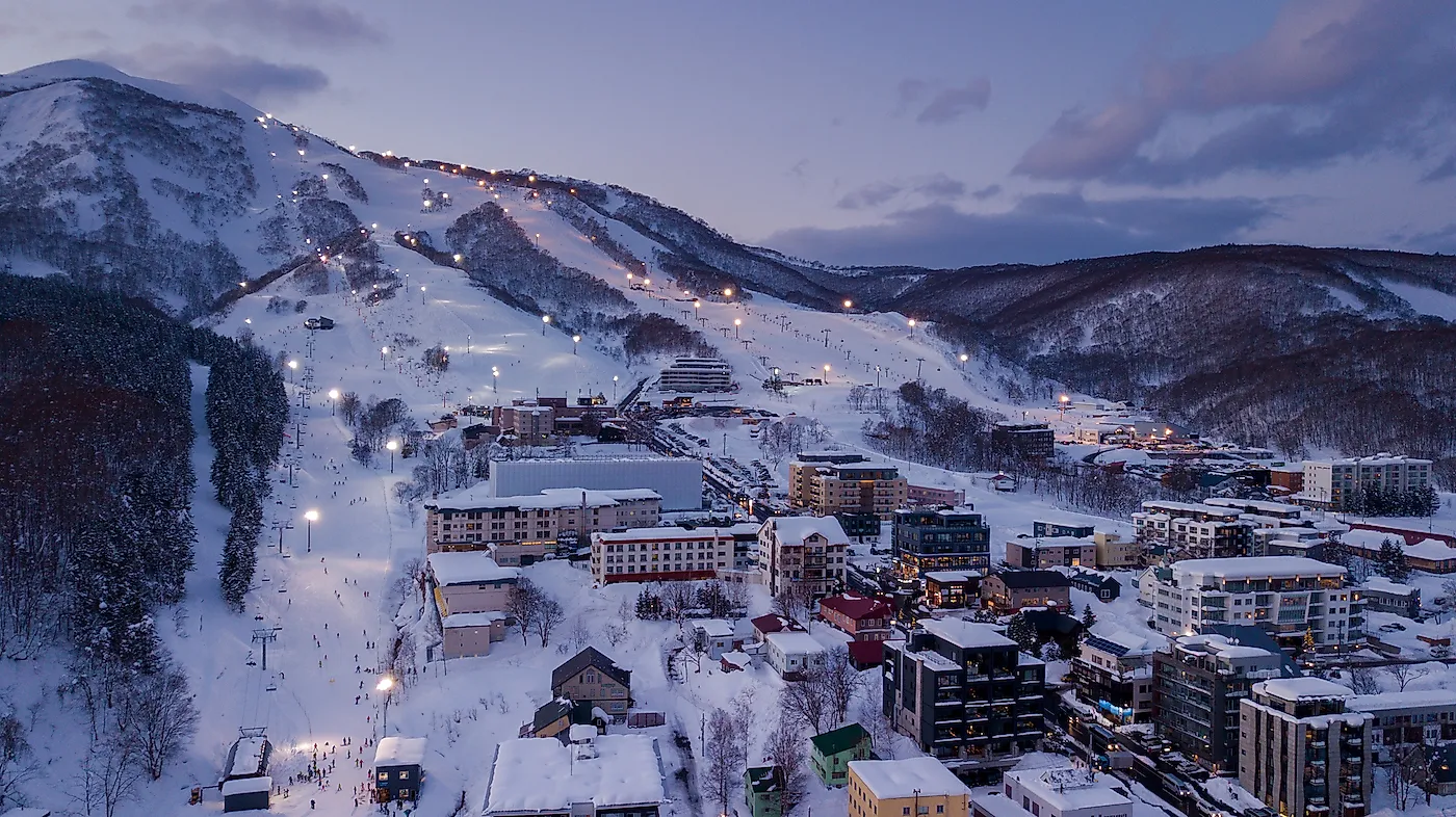 Aerial view at dusk of night skiing in Niseko Village. Niseko is a popular destination for ski resorts in Japan. Image credit: Cjmac/Shutterstock.com