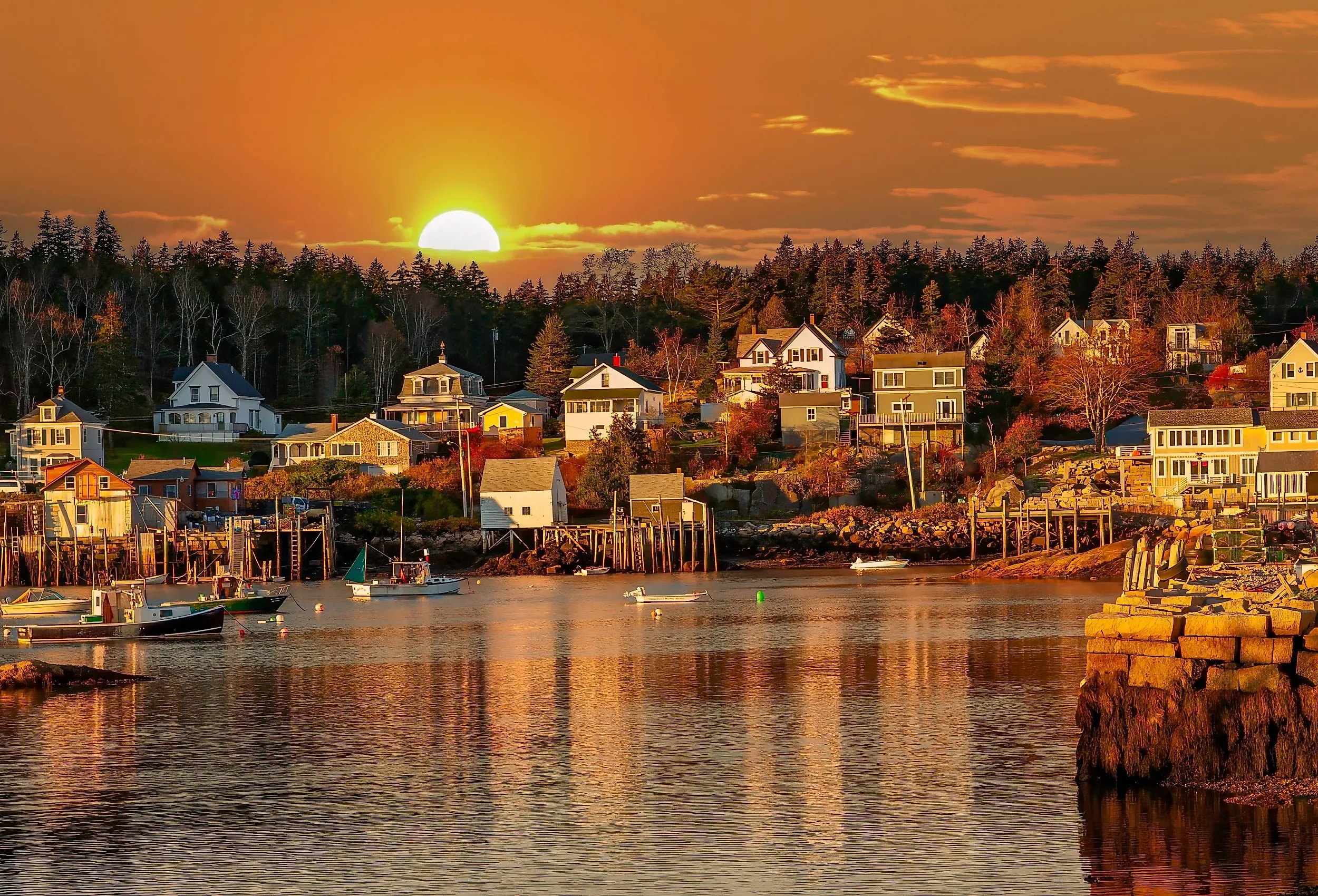 Lobster boats at anchor and bay front homes, Stonington, Maine at sunset