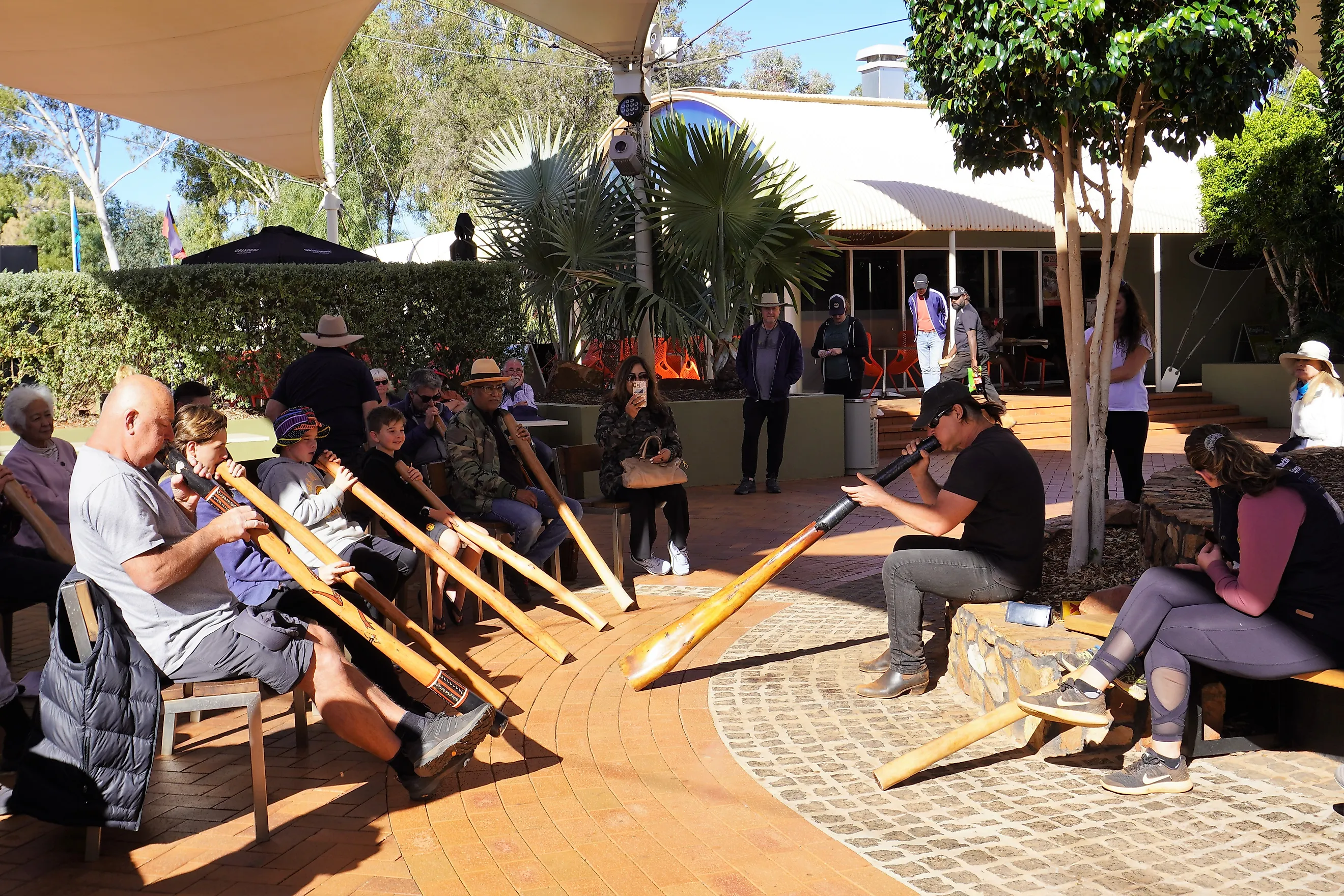 People receiving Didgeridoo Playing Lessons in Yulara, Northern Territory, Australia. Image credit: Annalucia / Shutterstock.com.