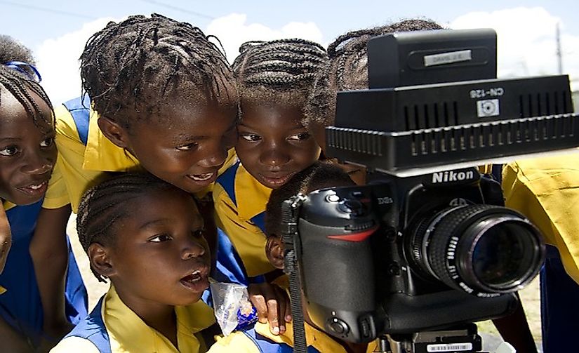 Schoolchildren in Jamaica examining a camera. English is the main language used in imparting education in Jamaica.