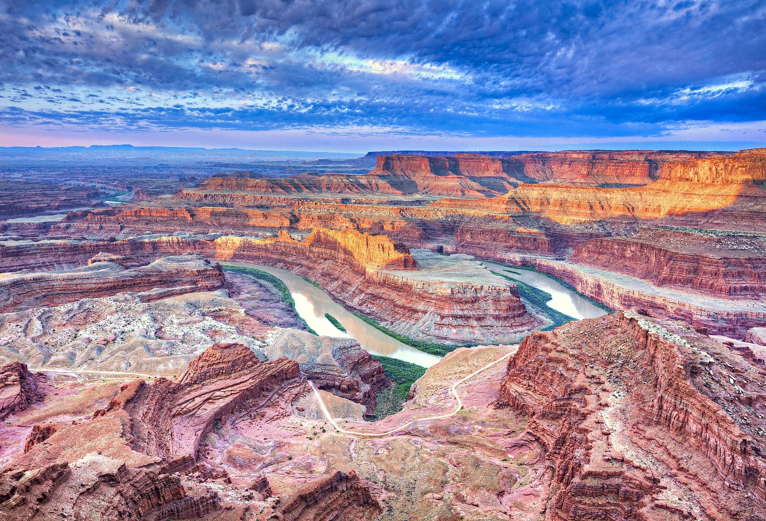 Sunrise illuminates clouds and the canyon walls of this colorful sunrise scene from Dead Horse Point, Utah.