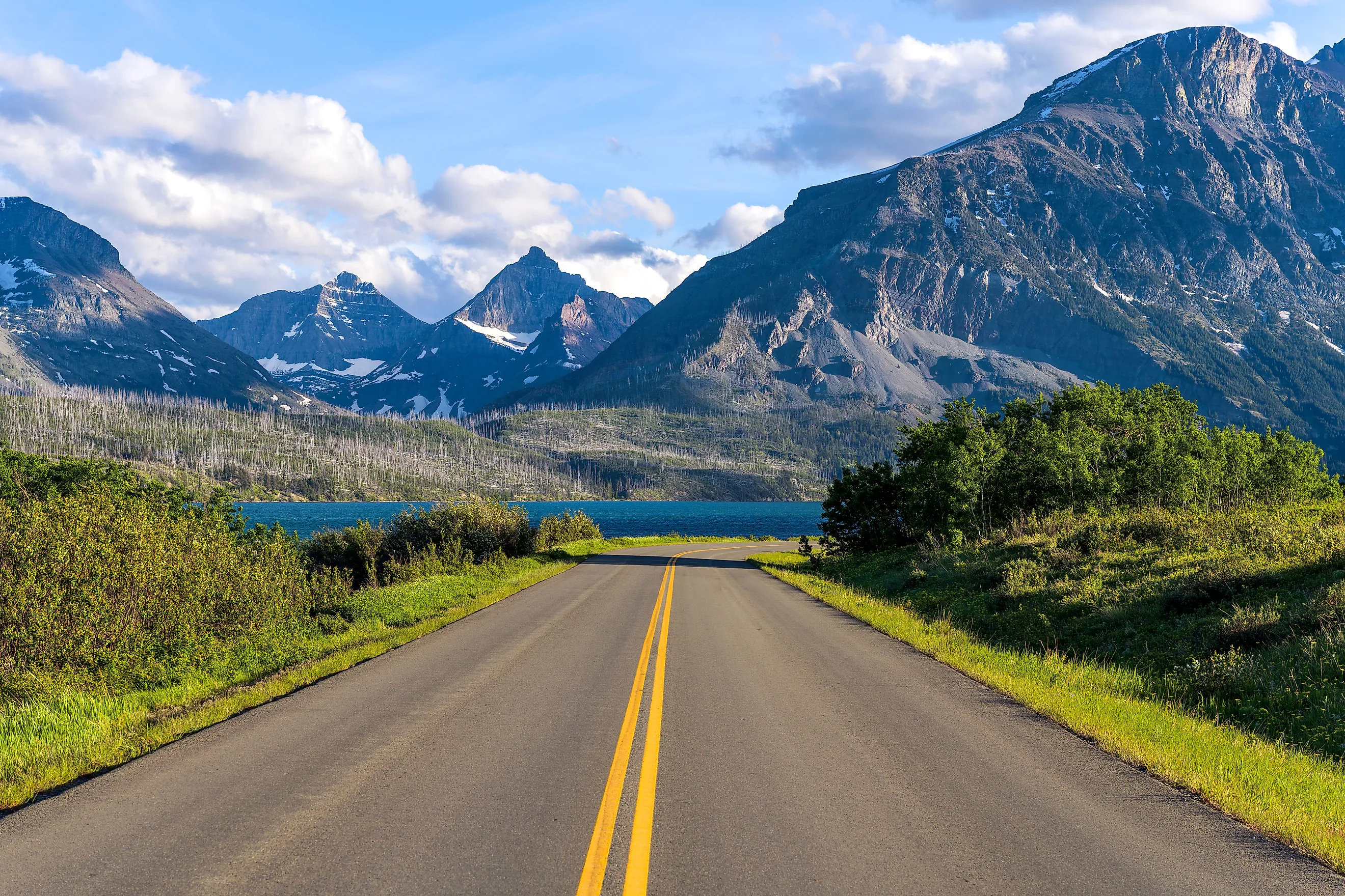 Spring evening view of the east section of Going-to-the-Sun Road at Saint Mary Lake, with rugged high peaks towering in the background, Glacier National Park, Montana, USA.