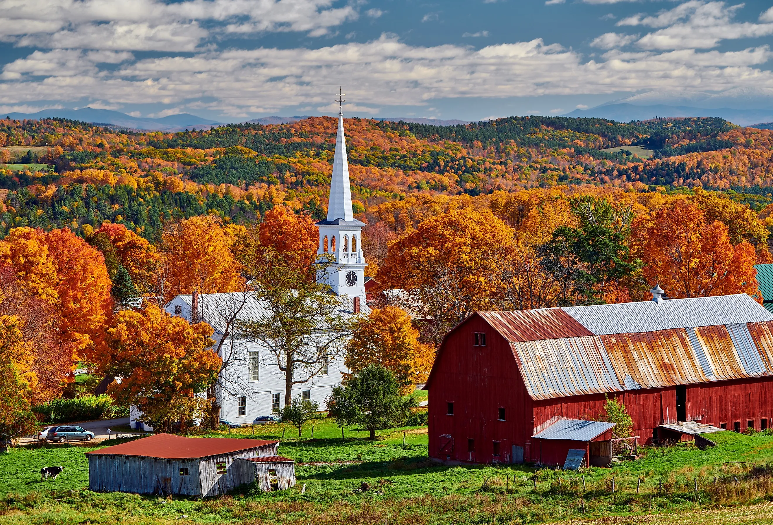 Congregational Church and farm with red barn on a sunny autumn day in Peacham, Vermont.