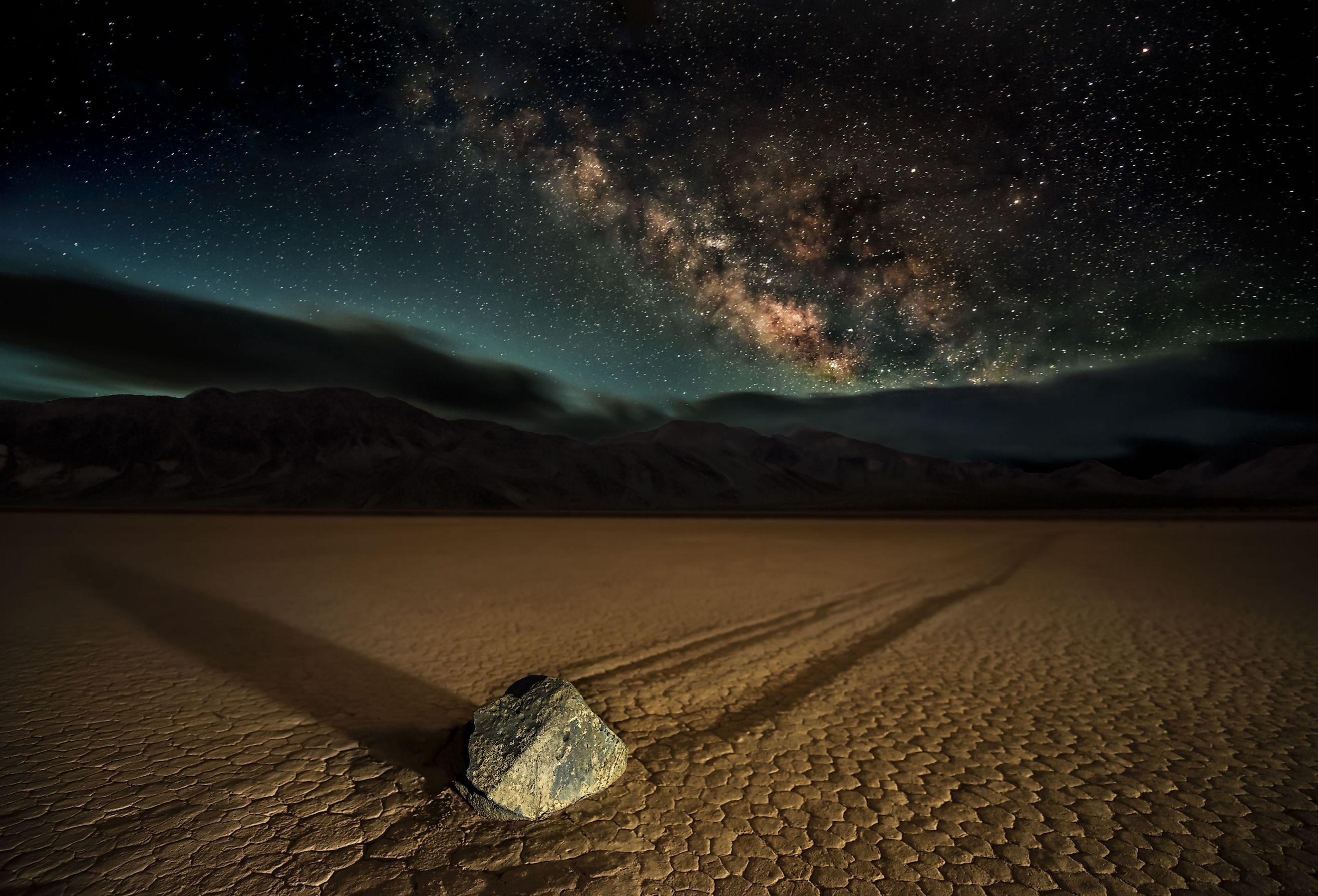 Racetrack Playa. A 'Sailing Stone' photographed at night under the Milky Way at California's Death Valley National Park at the Racetrack Playa. An alien, eerie, and mysterious spectacle.