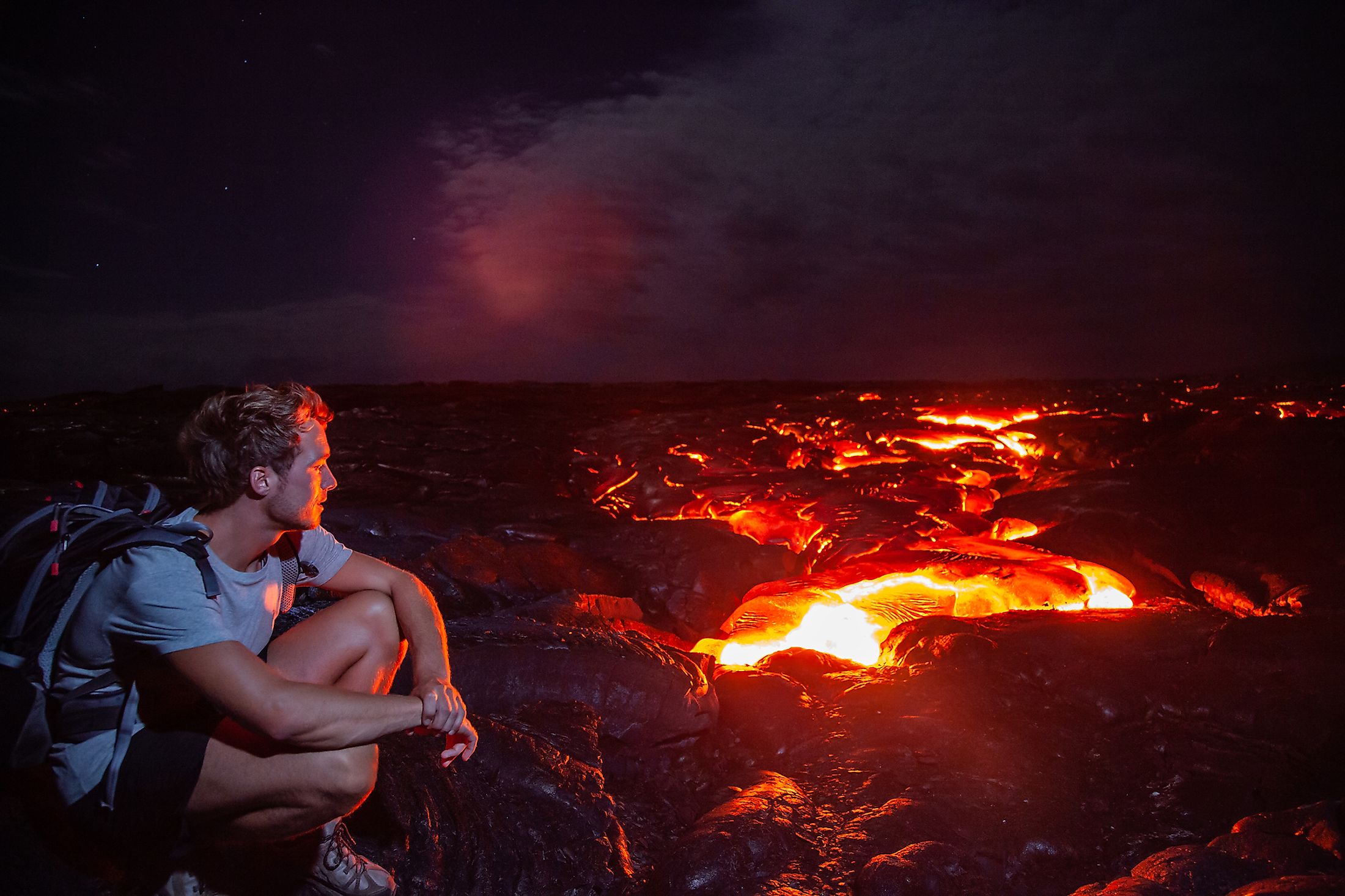 A hiker watching the lava flow of Kilauea.