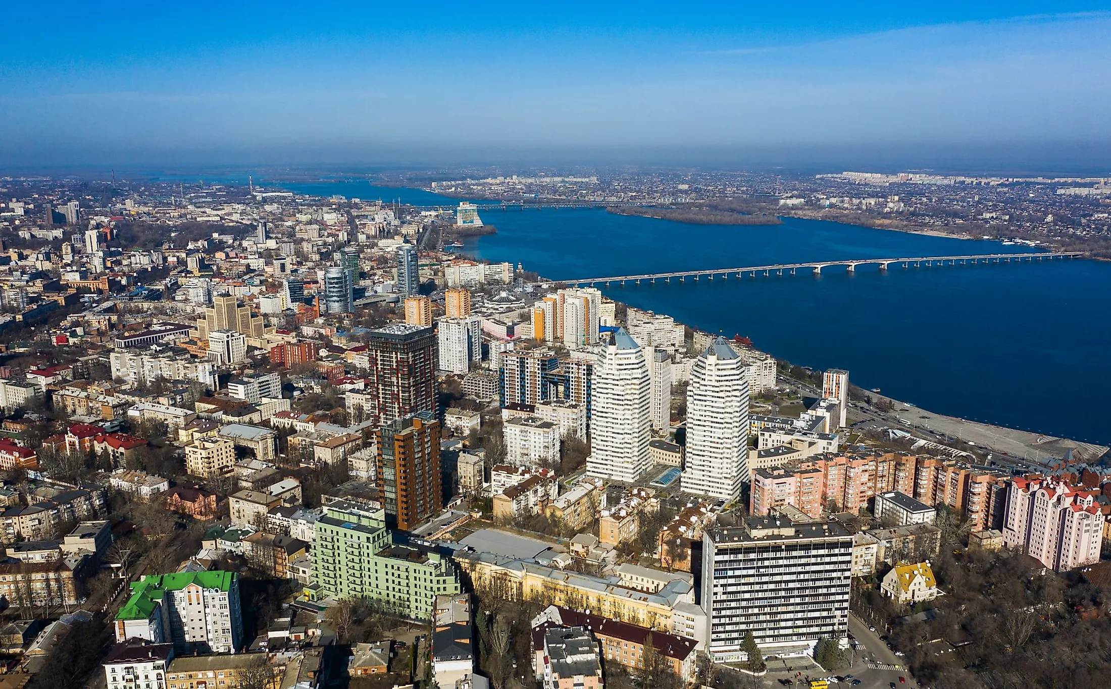 Aerial view of Dnipro city with the Dnieper River and different building blocks.