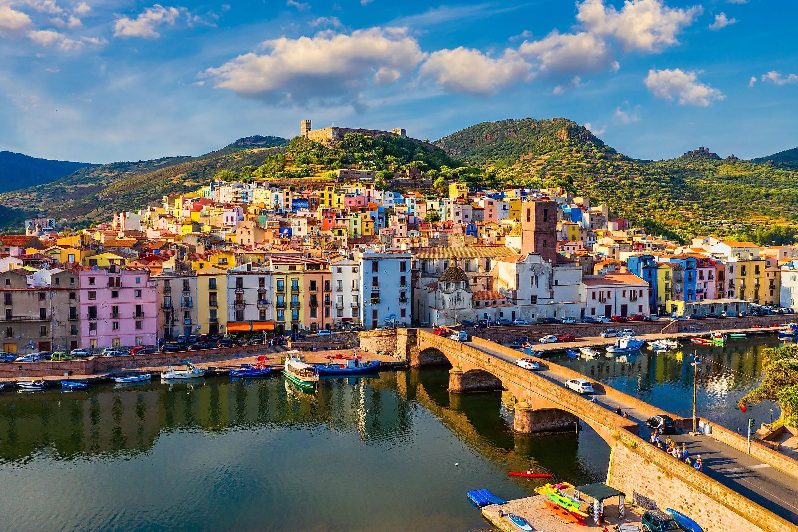 Aerial view of Bosa, Sardinia, with colored houses and a medieval castle.