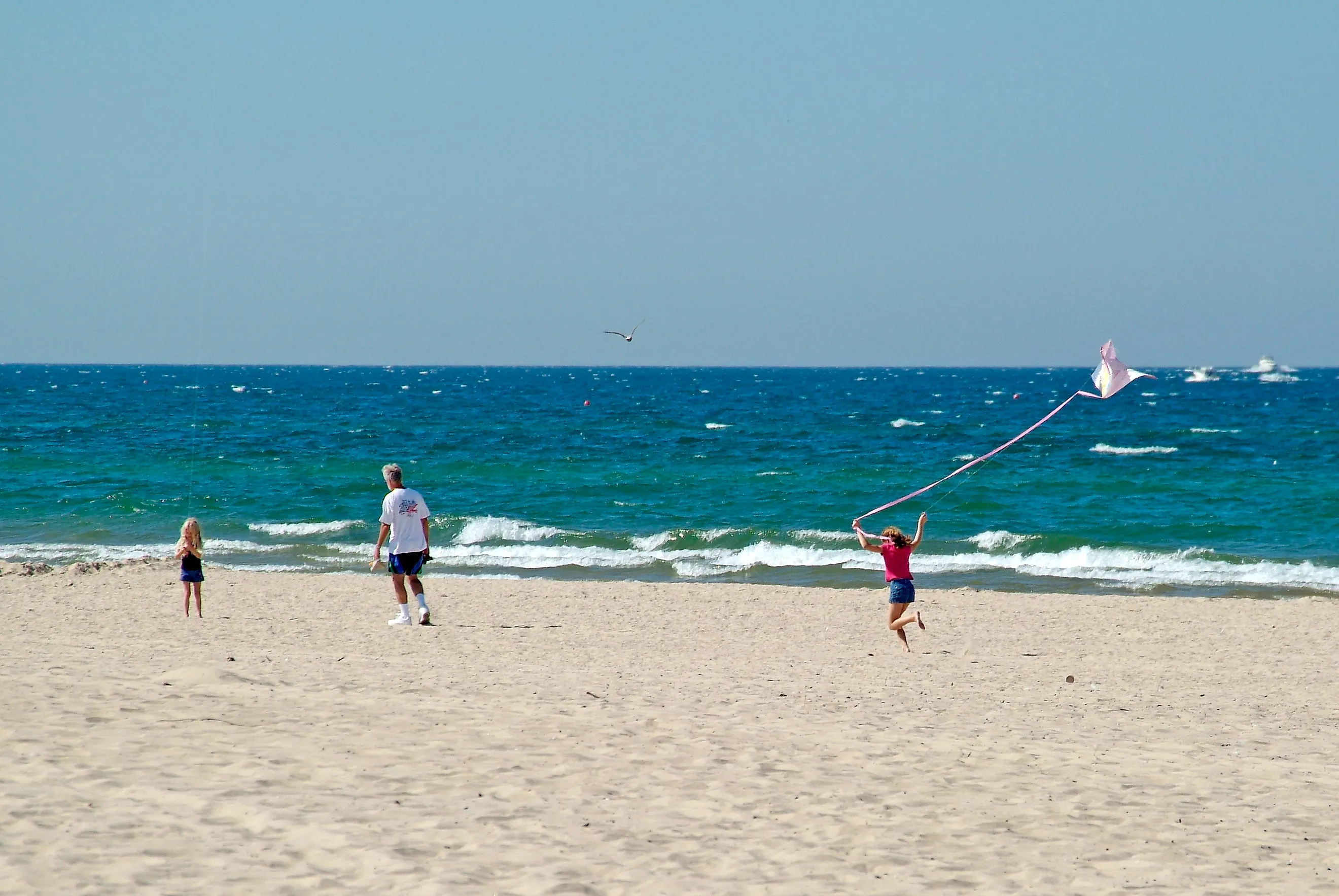 Girl flies kite on beach at Grand Haven State Park on Lake Michigan.