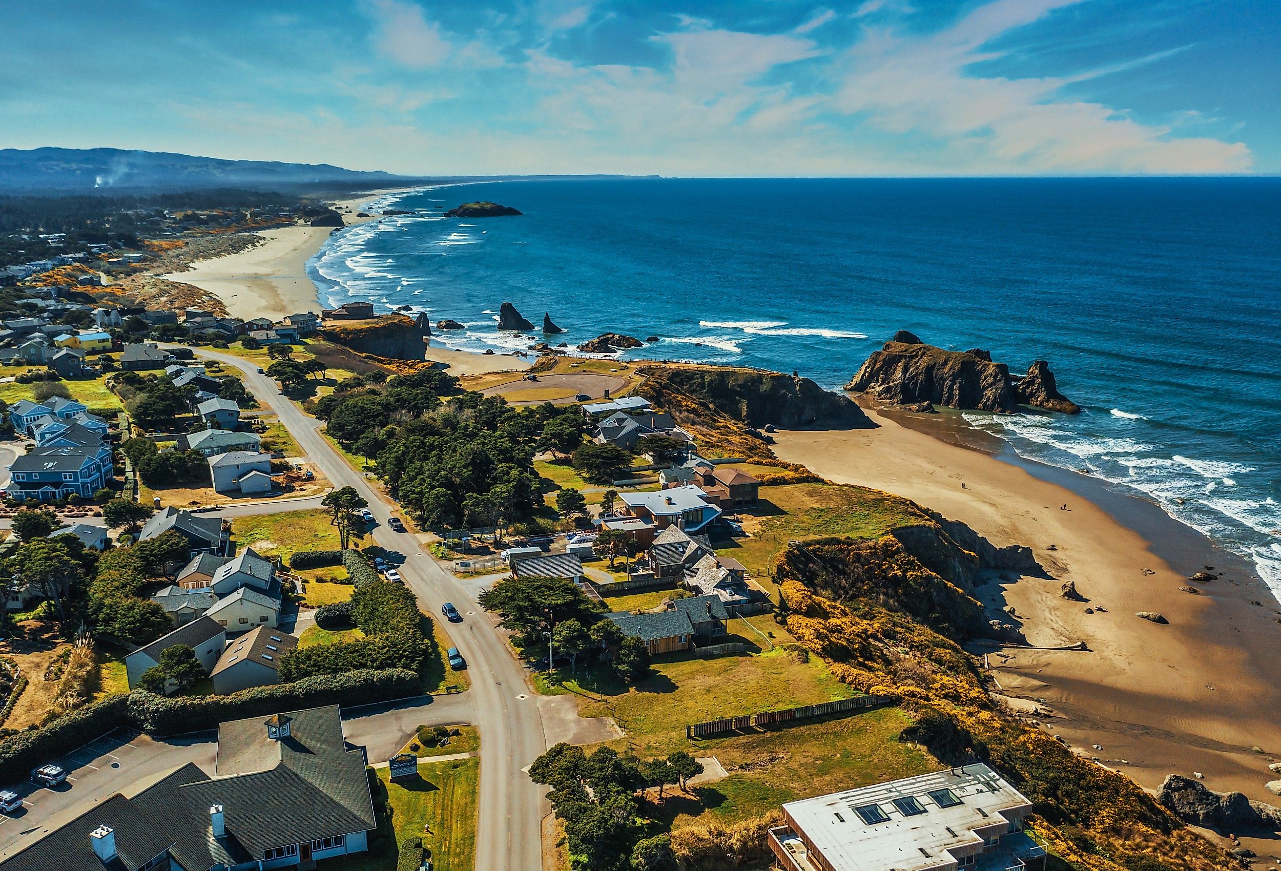 Aerial drone shot of coastal homes and beach in Bandon, Oregon.