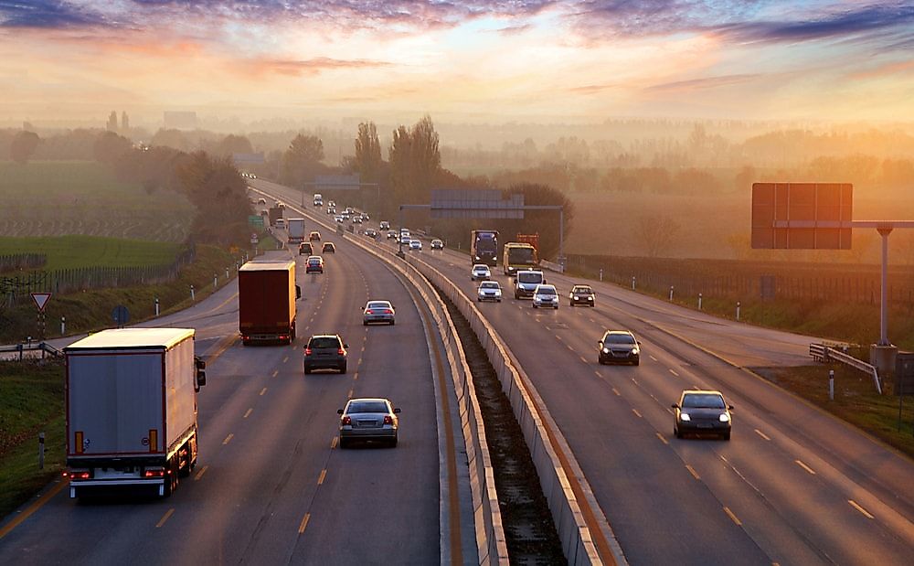 A photo of a highway in England, showing traffic driving on the left hand side.