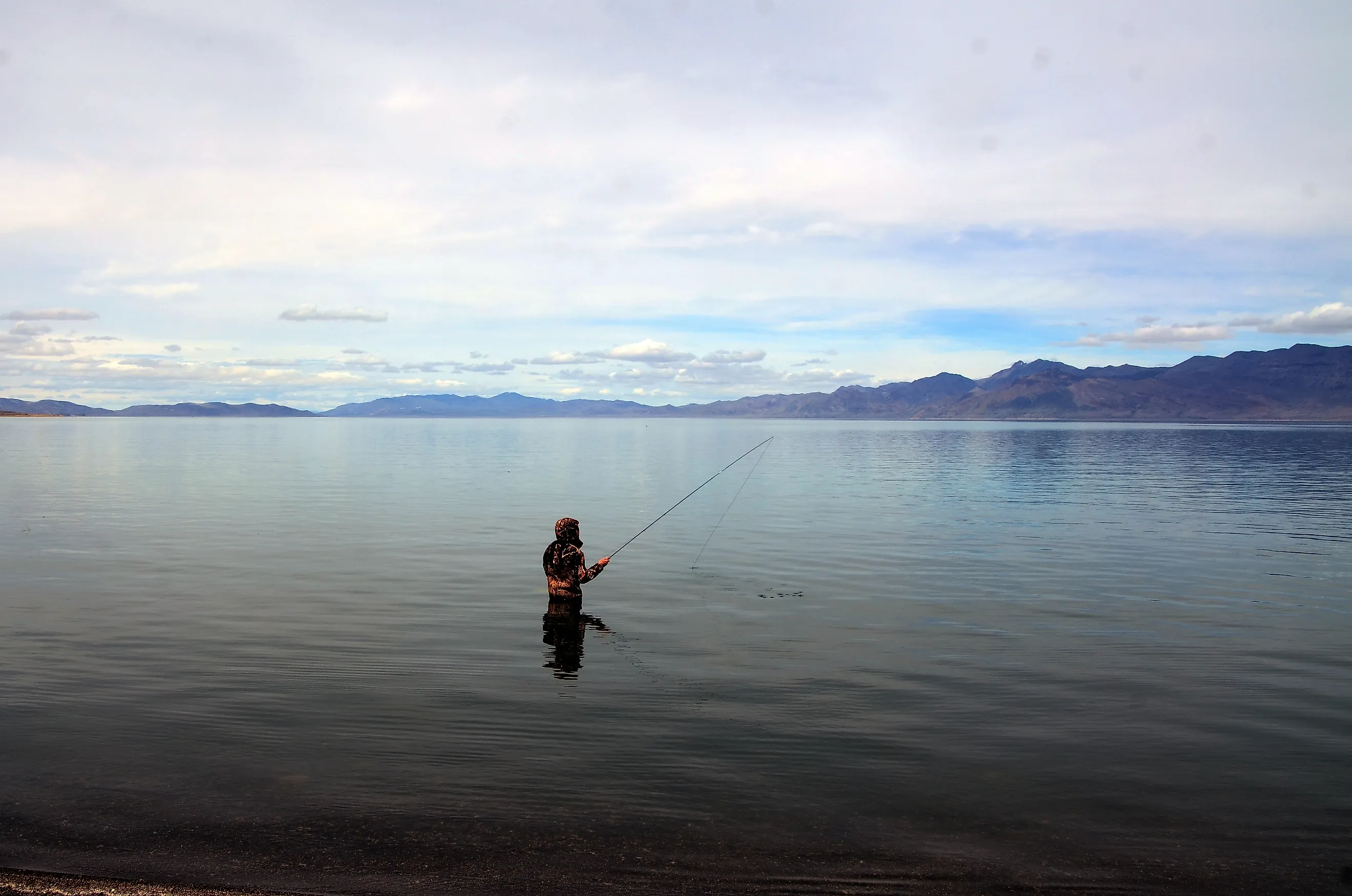 A fisherman fishing in Pyramid Lake which is a large natural lake and a world-class fishery in Nevada. Pyramid Lake, Nevada, United States Editorial credit: Daniel L. Locke / Shutterstock.com