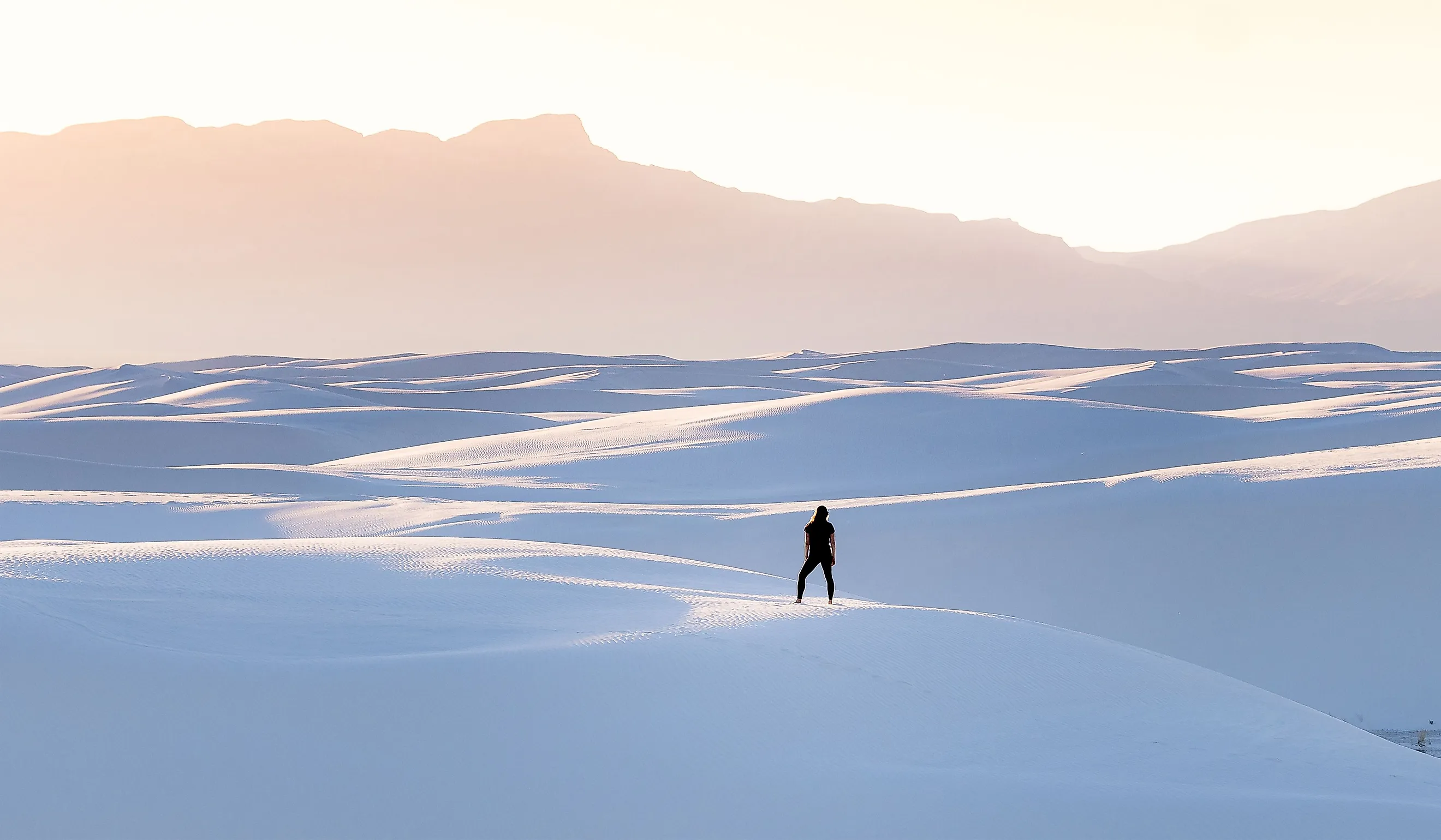 A female in black clothing admiring the view of mountains at White Sands National Park
