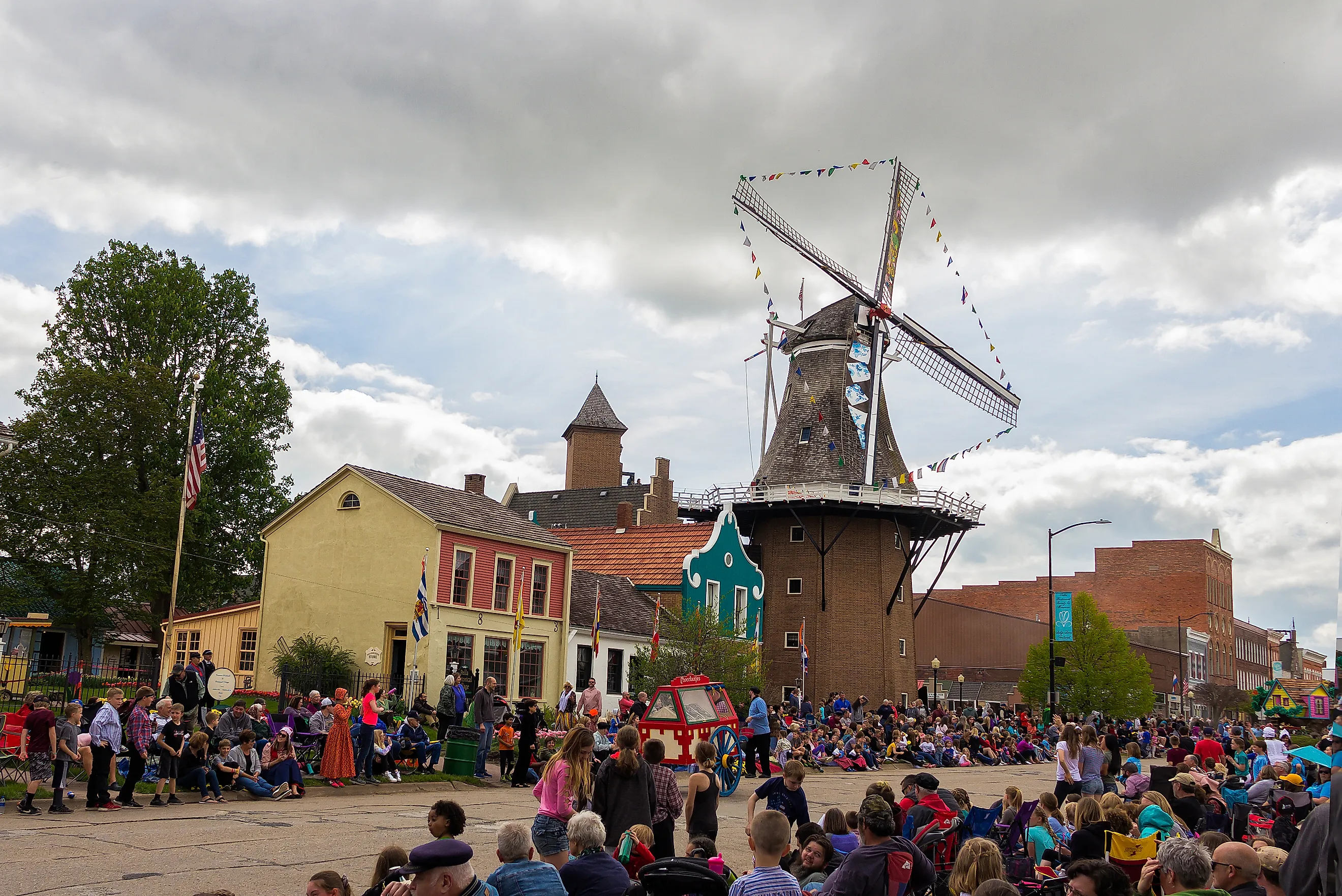 People celebrate the Tulip Time Festival in front of the Vermeer Windmill in Pella, Iowa. Image credit yosmoes815 via Shutterstock