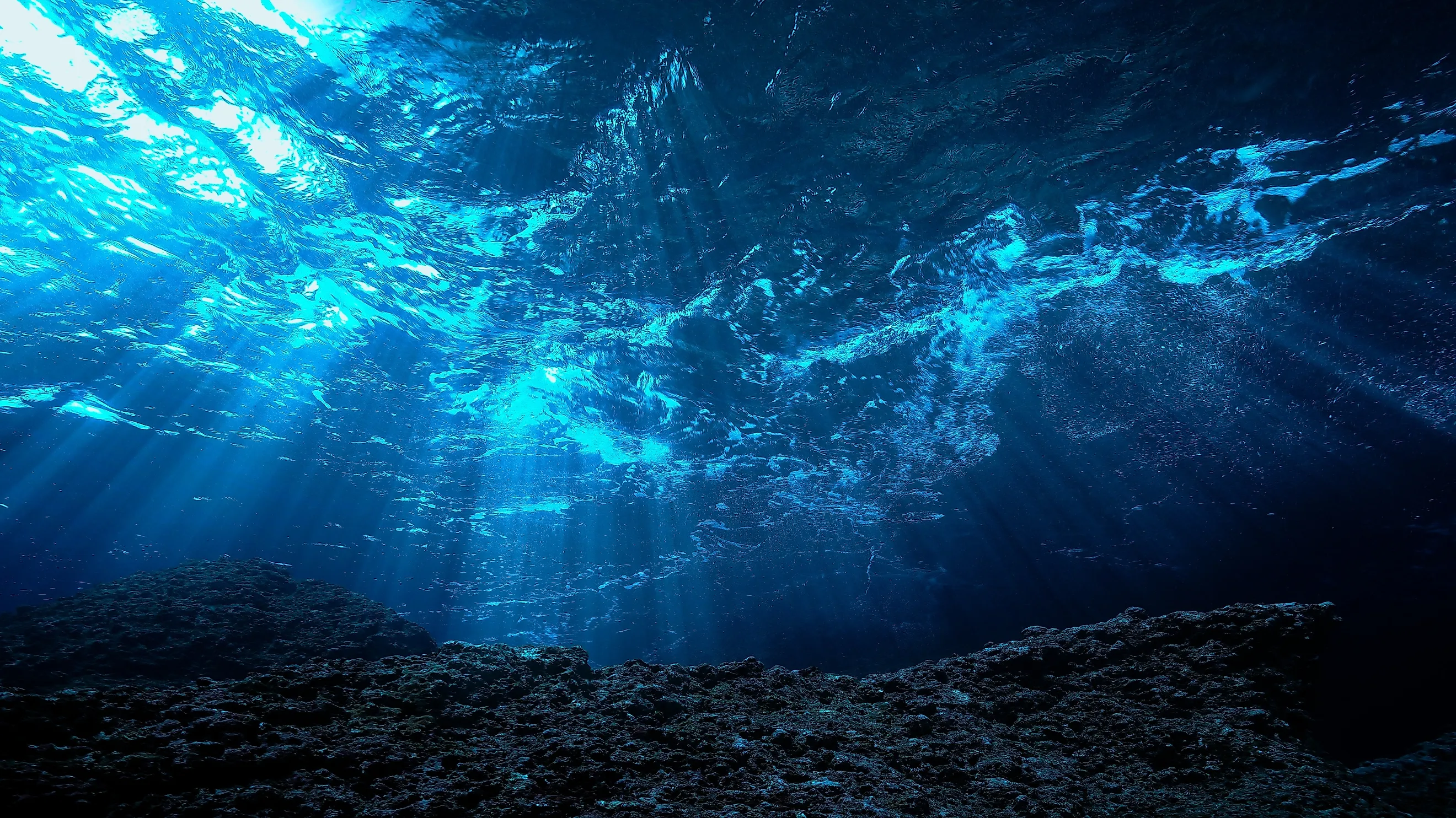 Underwater photo of rays light in the deep blue ocean.