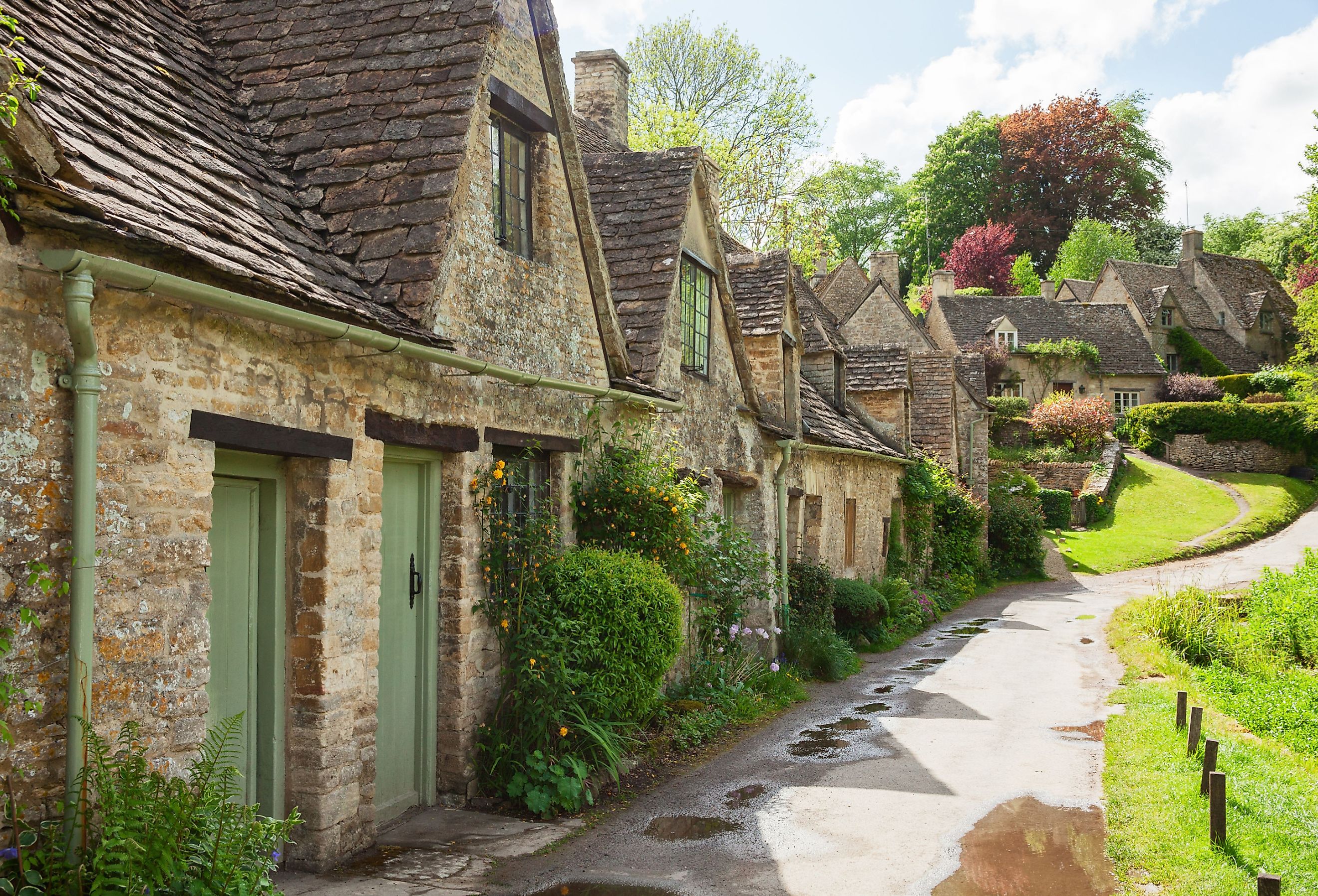 Old street with traditional cottages in beautiful spring day, Bibury, England, UK.
