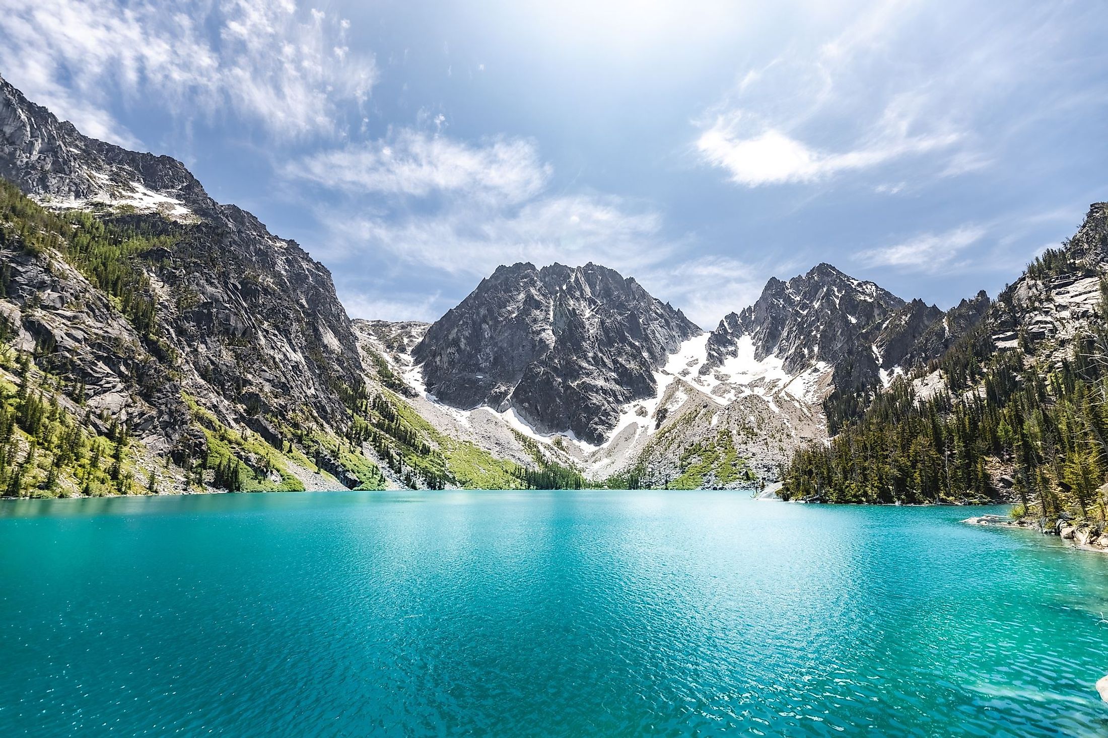 A scenic view of the Colchuck Lake against blue sky in bright sunlight, in Chelan County, Washington. 