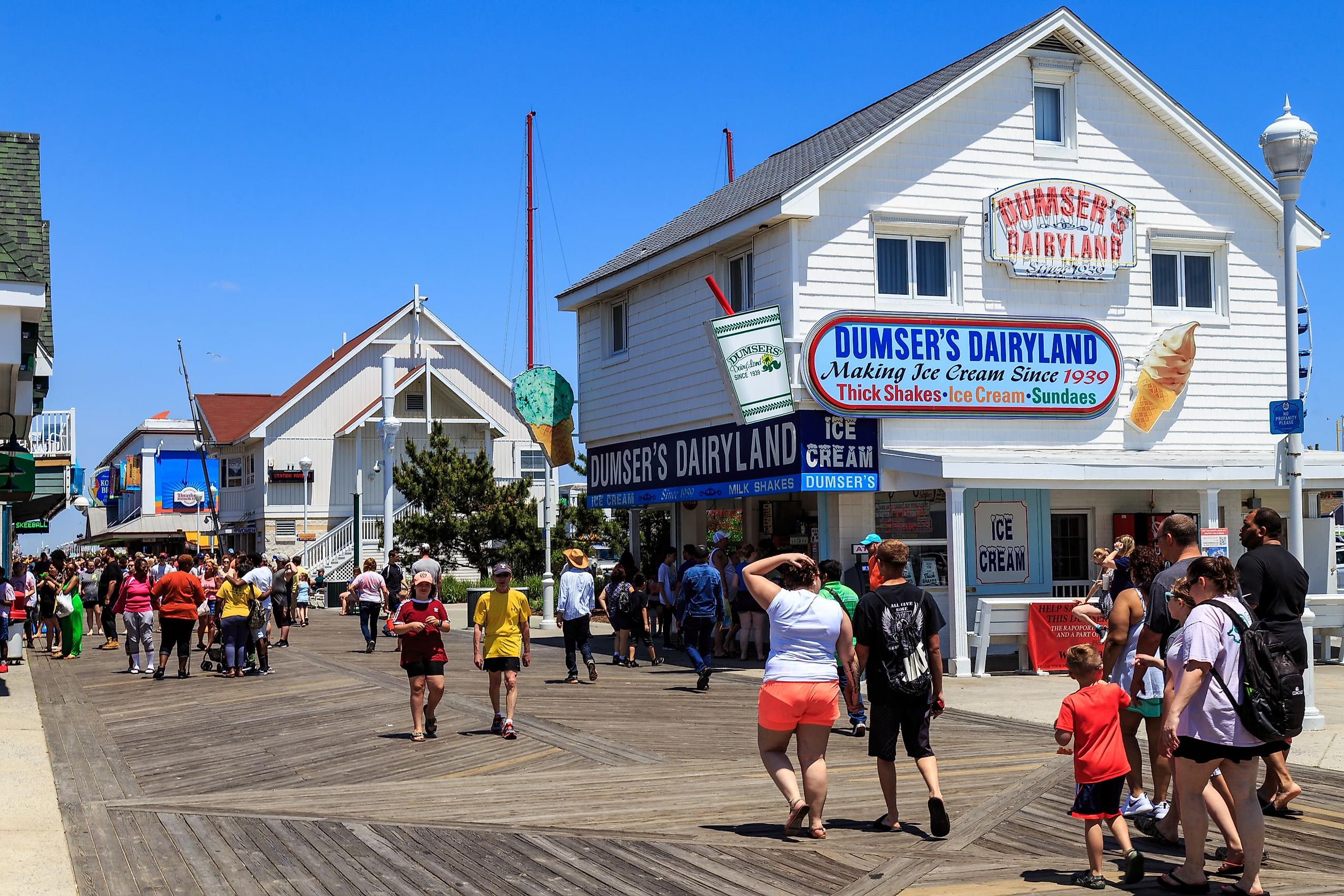 Stores, shops, and eateries attract visitors on the Ocean City boardwalk in Ocean City, Maryland, USA. Editorial credit: George Sheldon / Shutterstock.com