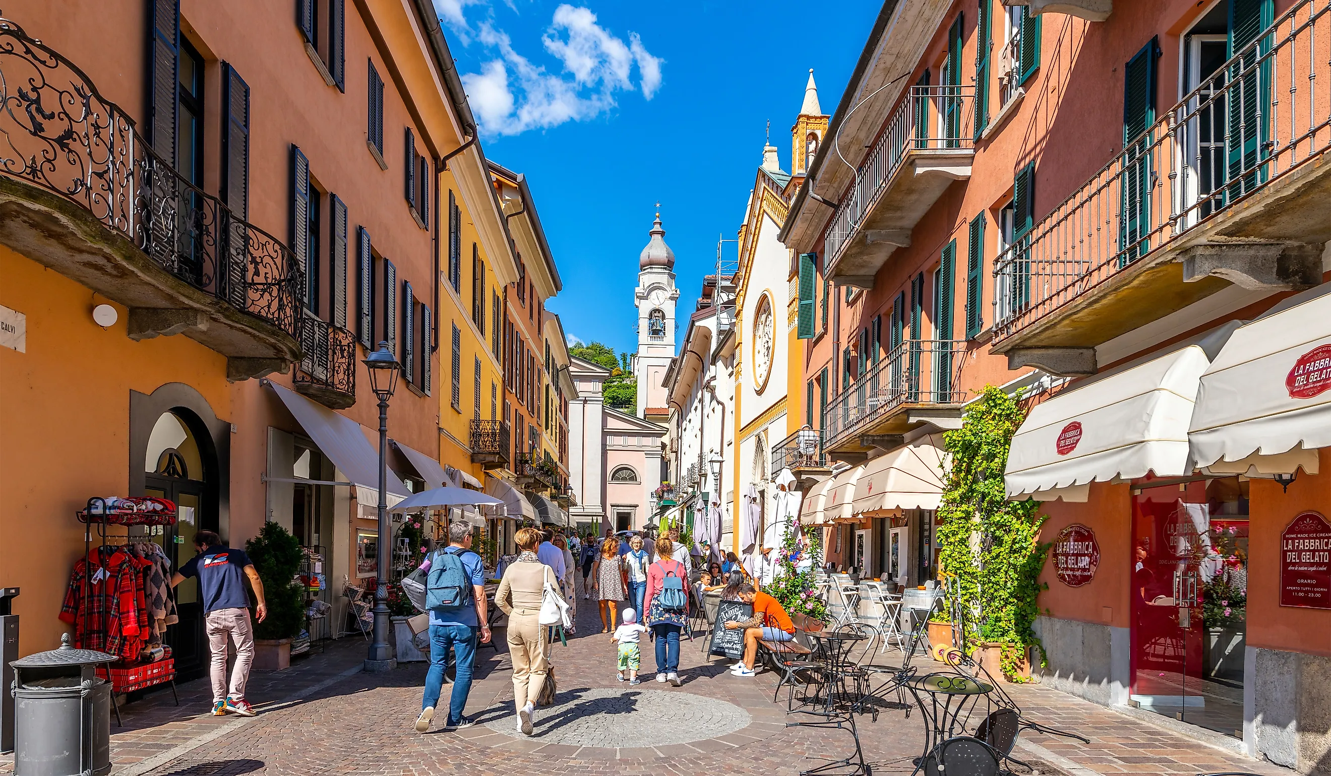 A colorful narrow street of shops and cafes in the medieval old town center of Menaggio, Italy, on the shores of Lake Como. Editorial credit: Kirk Fisher / Shutterstock.com