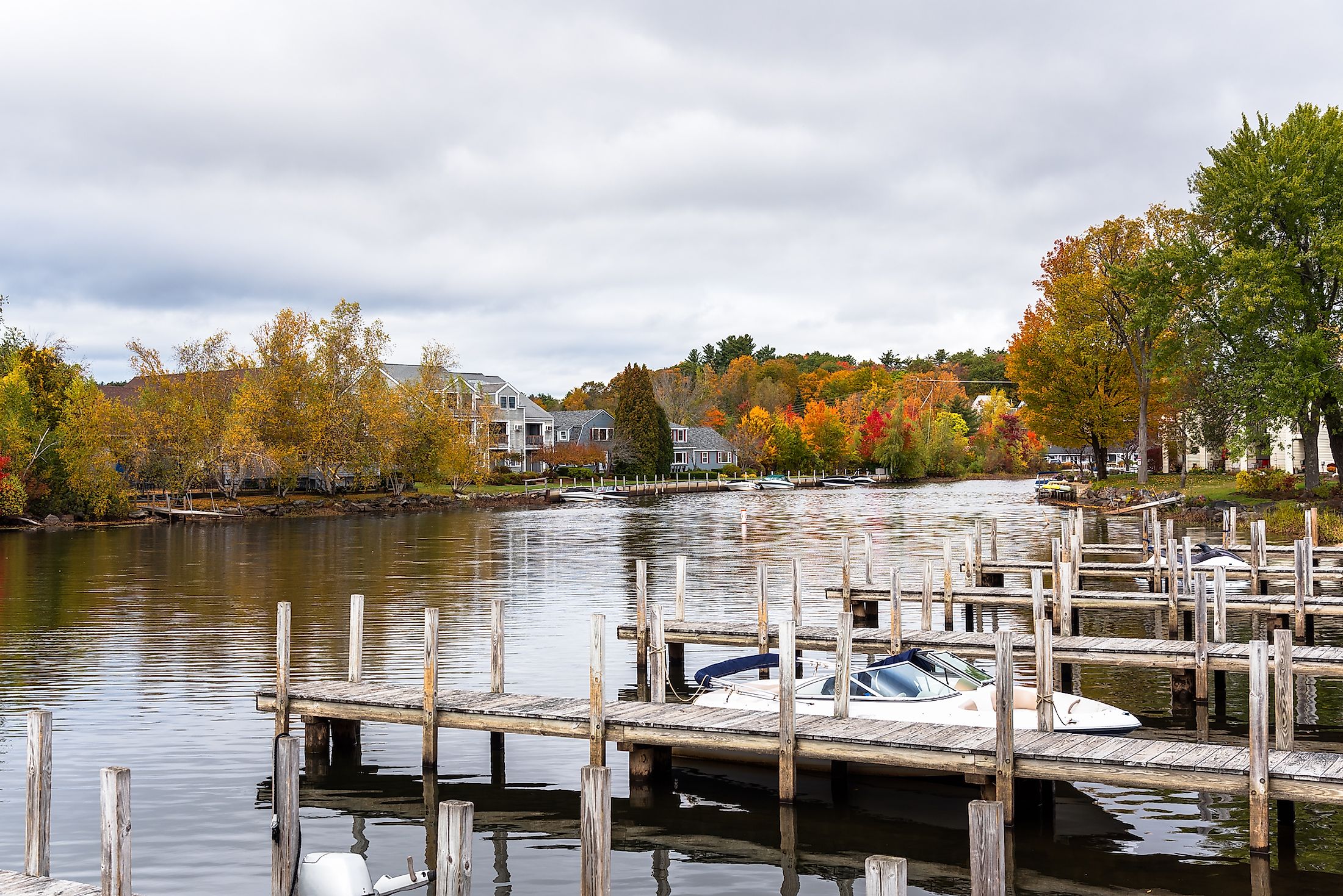 Colorful autumnal trees on river bank in Wolfeboro, New Hampshire, US.