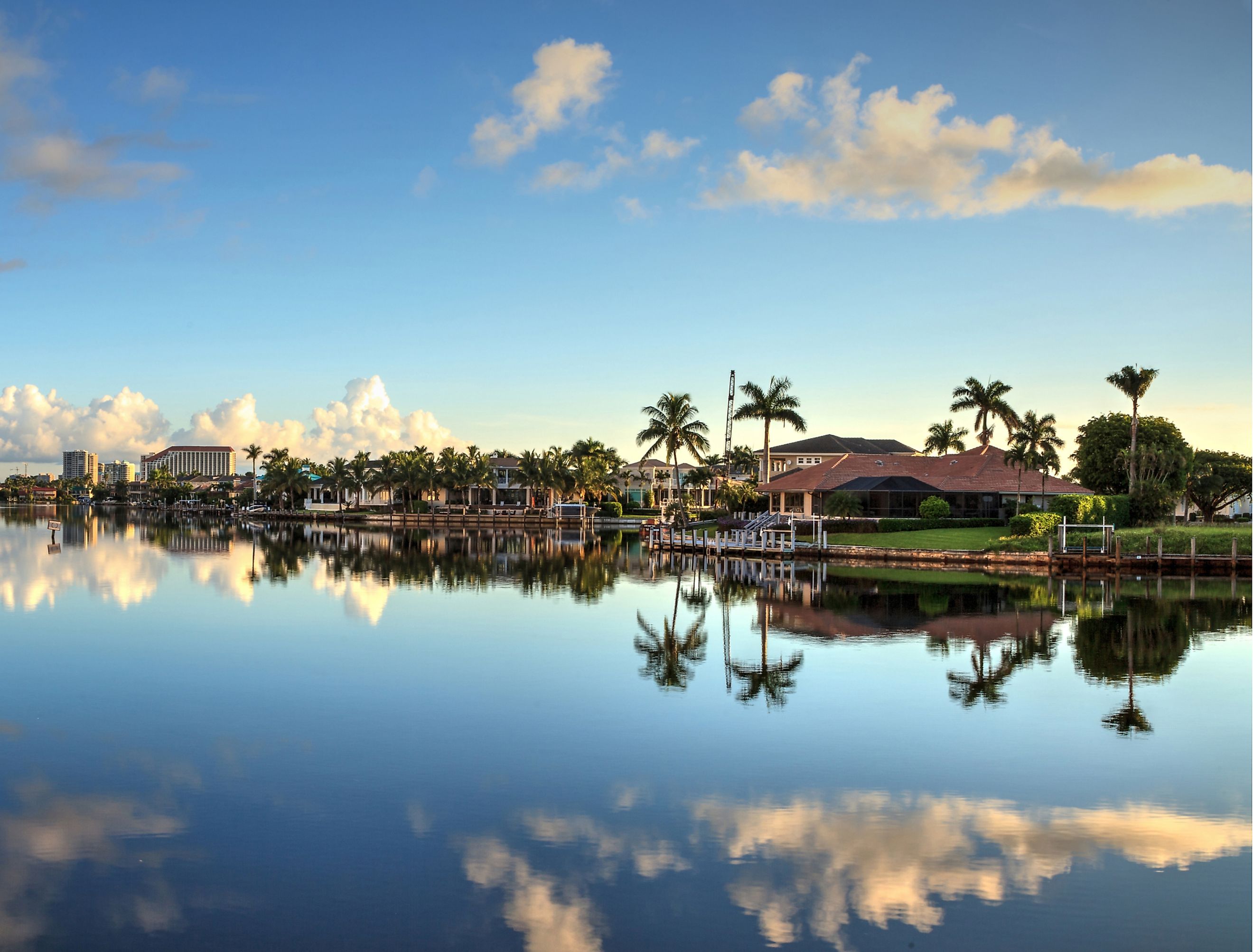 Reflection in the water of buildings along the Village at Venetian Bay in Naples, Florida.