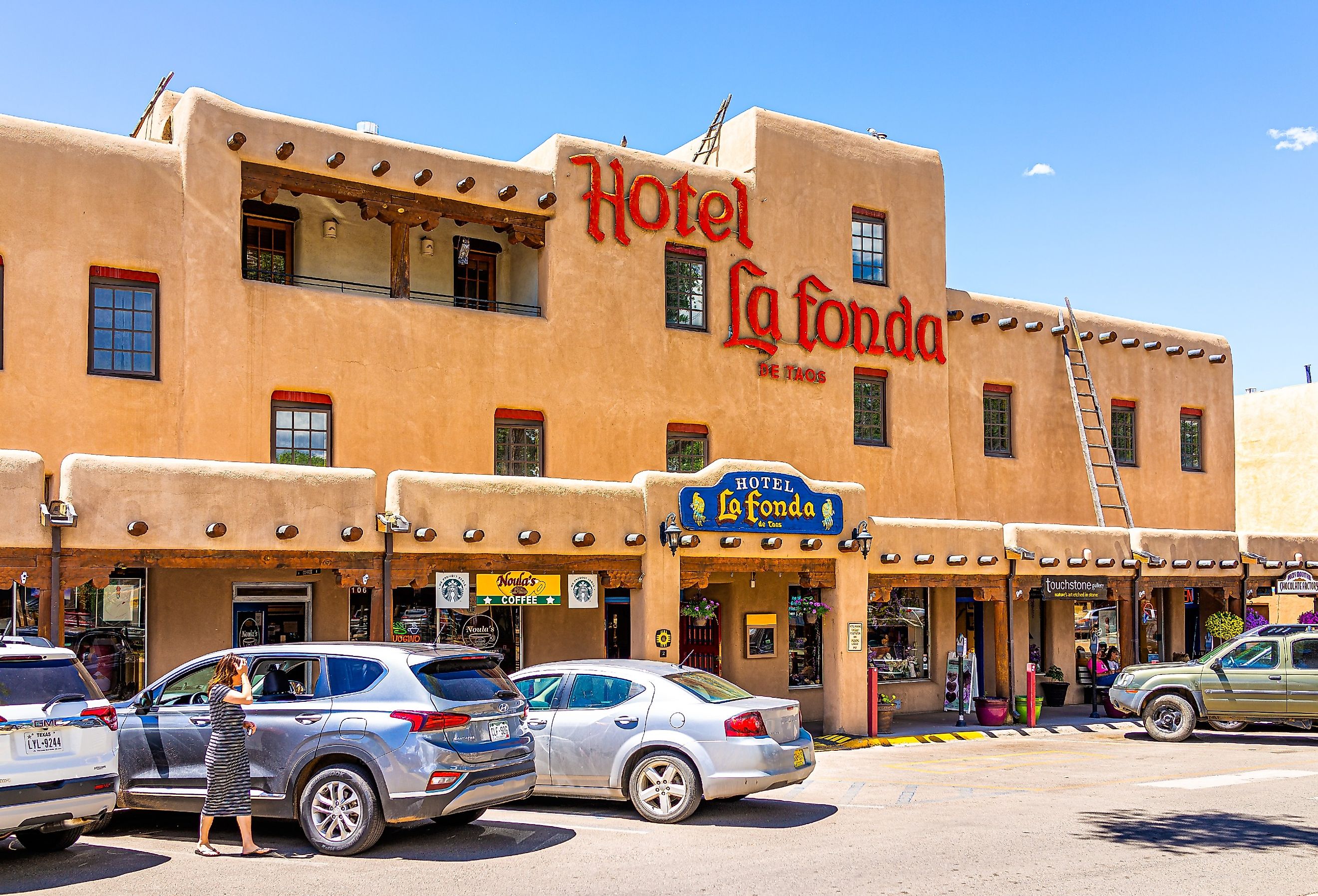 Downtown McCarthy's plaza square in famous town city village old town with sign exterior for Hotel La Fonda, Taos, New Mexico. Image credit Andriy Blokhin via Shutterstock