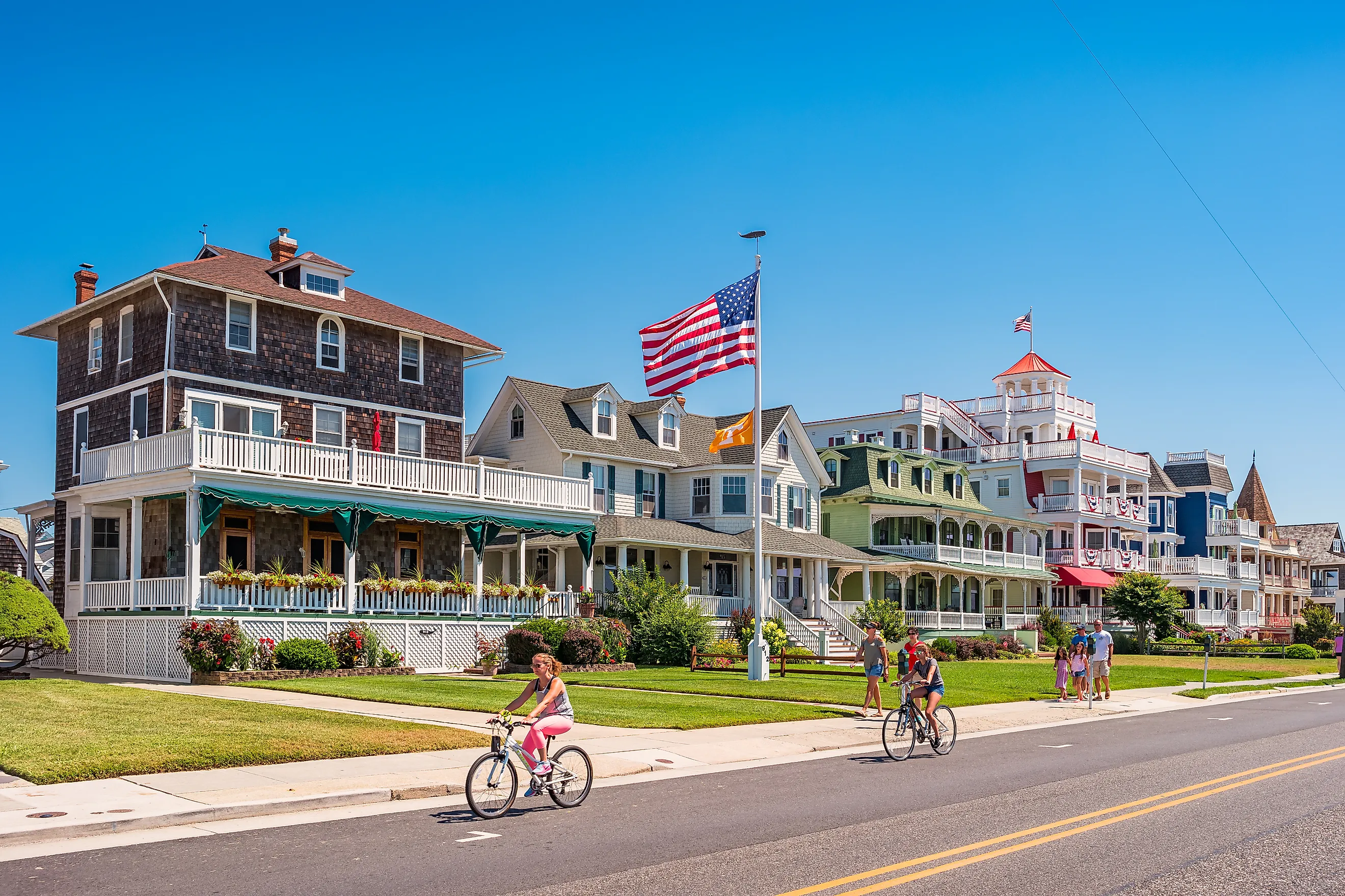 People bike and walk in front of traditional villas in Cape May, New Jersey.