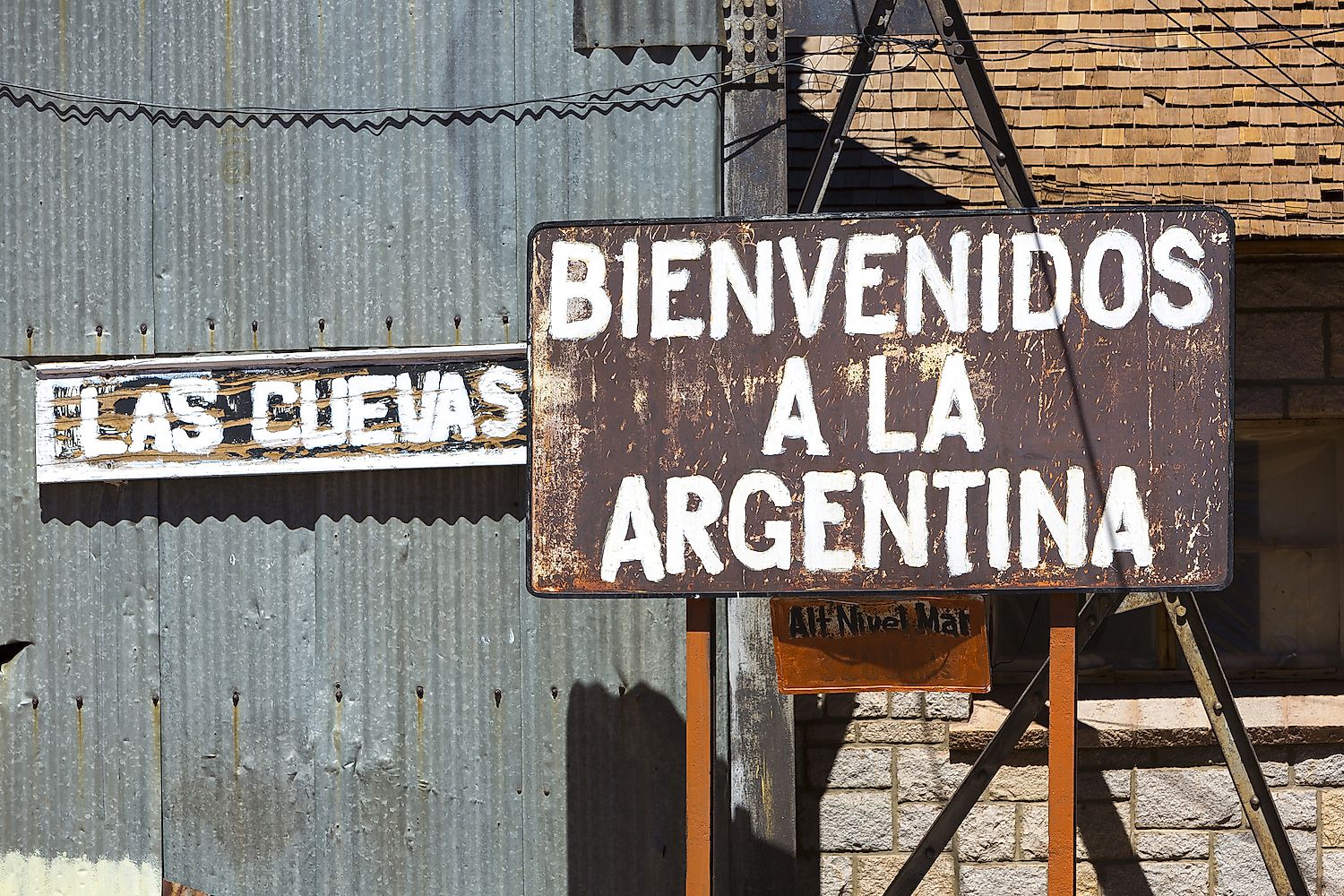 Rusted old retro sign saying welcome to Argentina written in Spanish at an old train station at the border of Chile and Argentina near the Aconcagua National Park. Image credit: Watch the World/Shutterstock.com