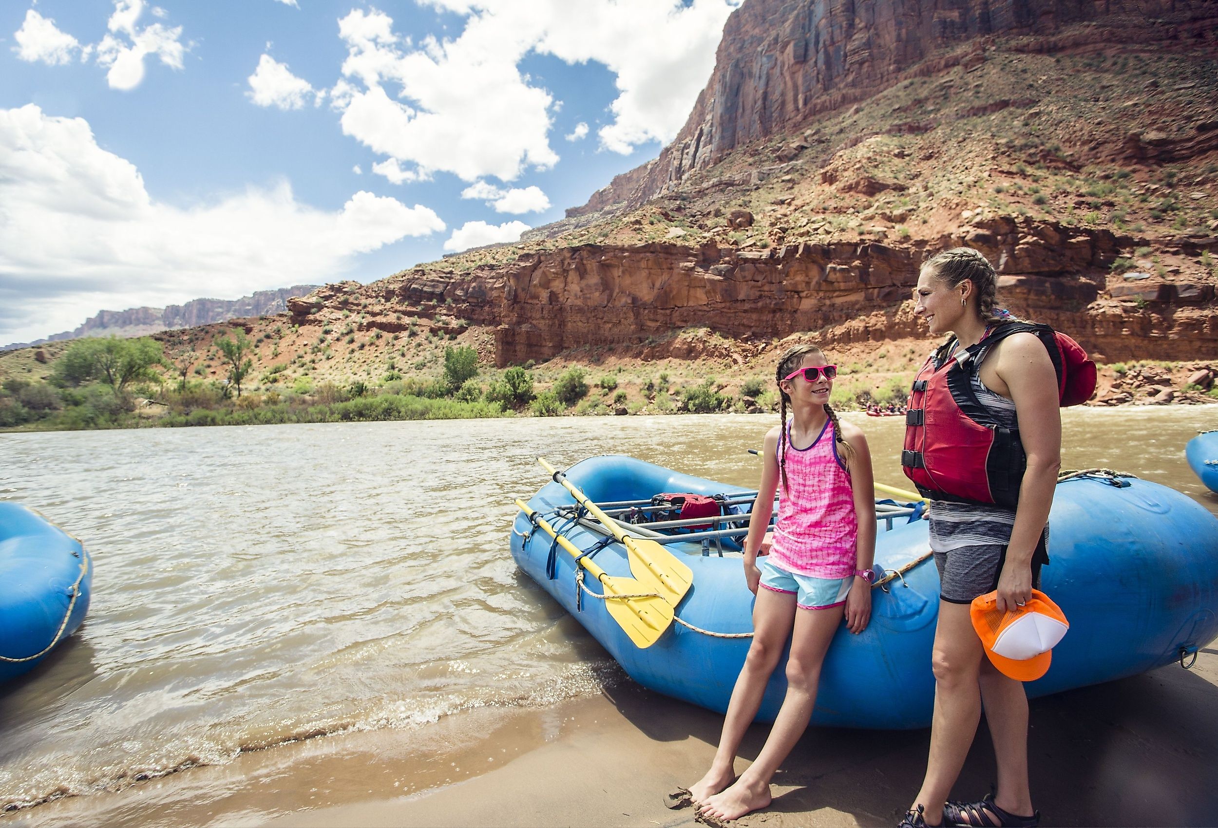 Smiling child and adult women ready to board a large inflatable raft as they travel down the scenic Colorado River near Moab, Utah and Arches National Park.