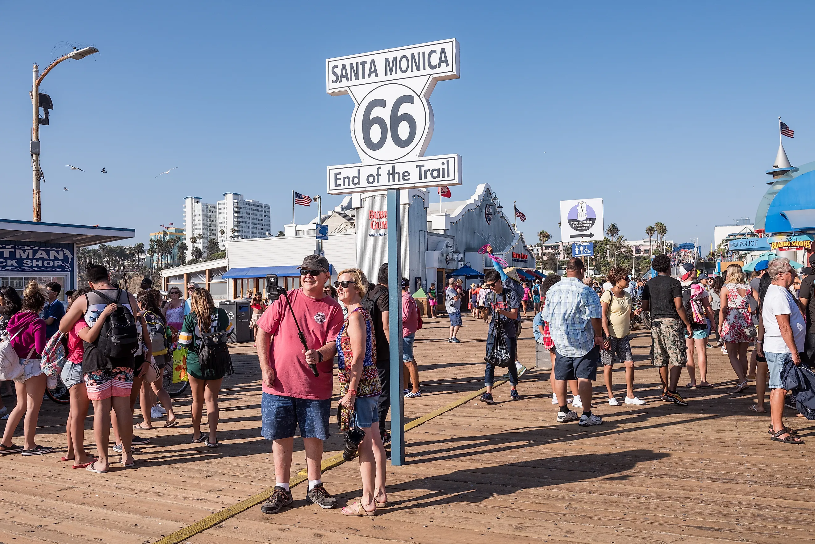 Santa Monica, CA: Crowd of tourists surround the road sign for the end of the famous Route 66 on the Santa Monica Pier in Los Angeles County. Editorial credit: Sandra Foyt / Shutterstock.com